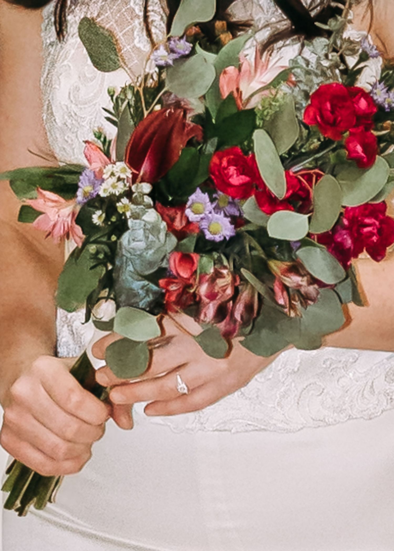 Close-up of bridal bouquet featuring red roses, purple flowers, and eucalyptus greenery.