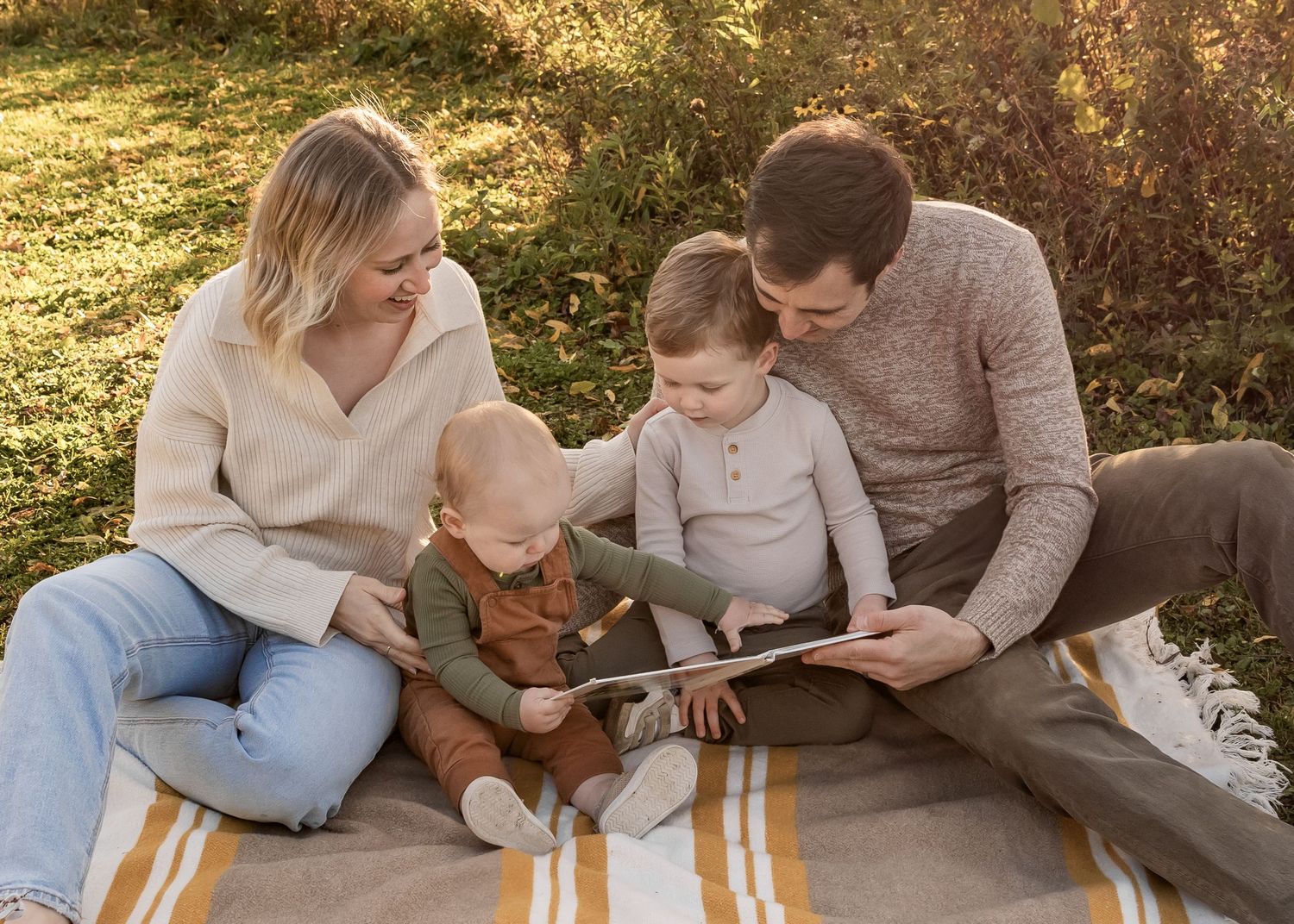 Young family laughing together during a sunset photography session at Indian Lake County Park near Madison, Wisconsin.