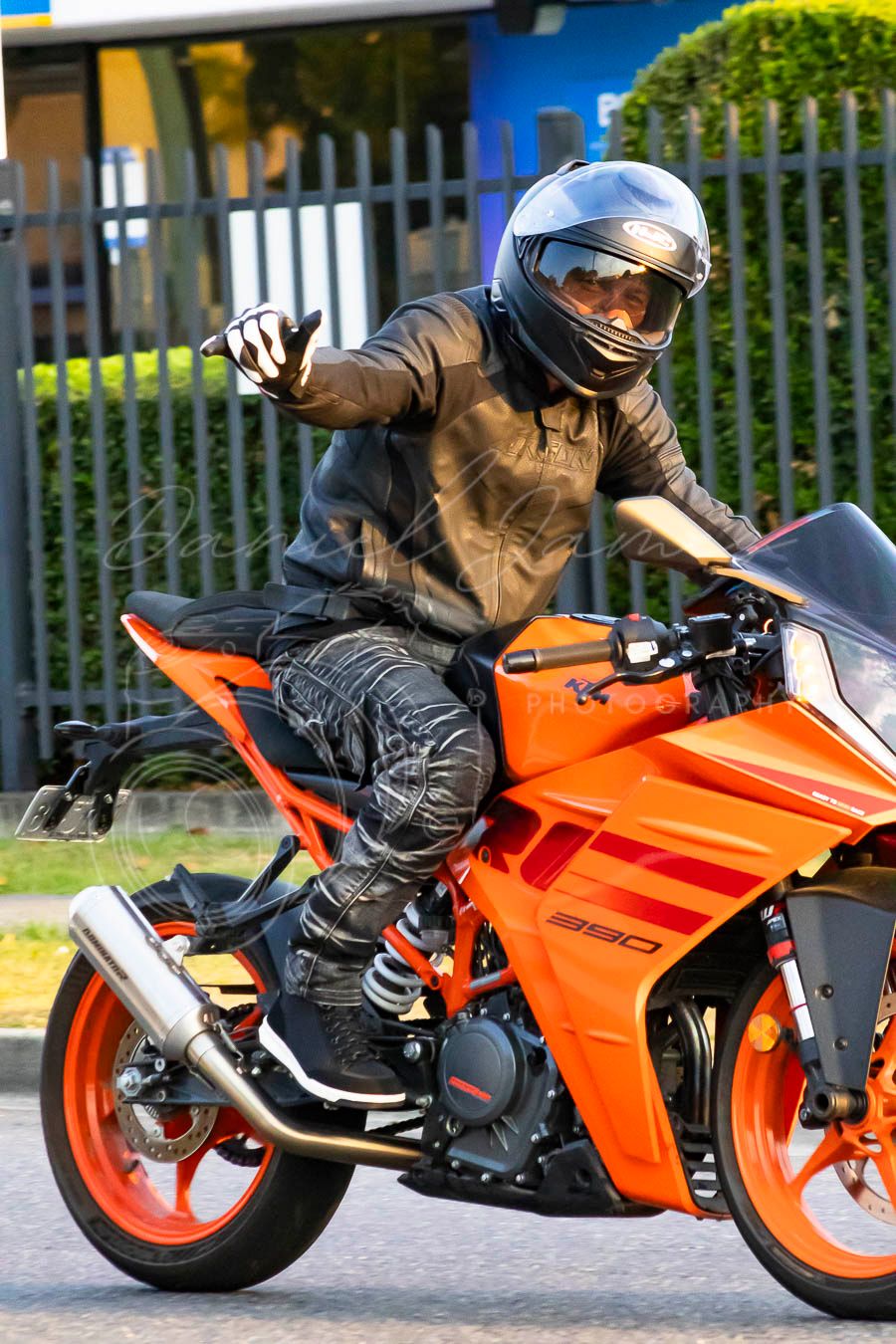 Motorcyclist riding an orange sport bike through a series of action shots showing dynamic cornering techniques.