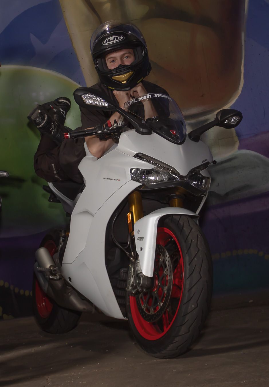 White Ducati sportbike with red accents photographed in low light conditions.