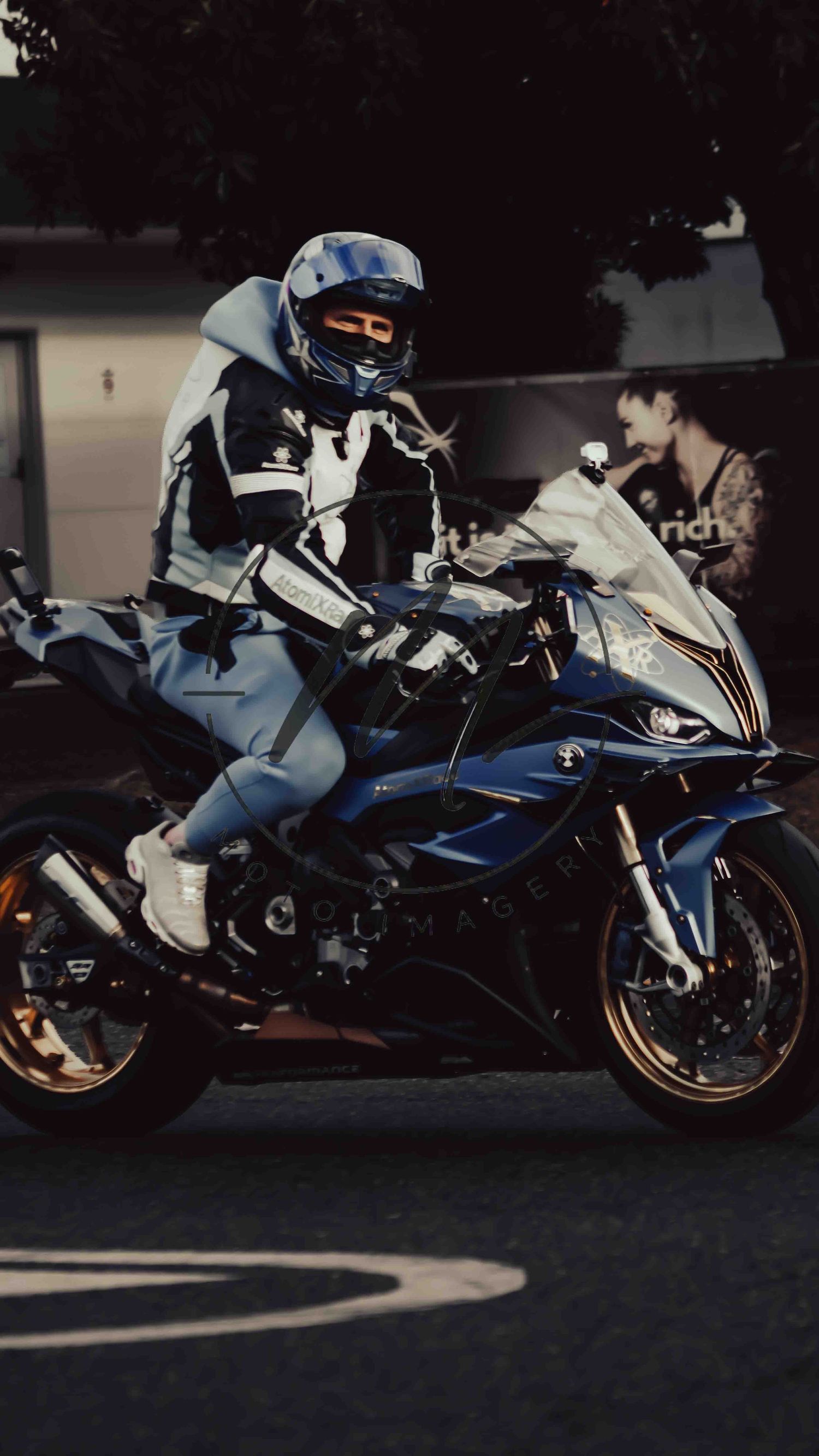 A motorcyclist in full racing gear and helmet rides a blue BMW S1000RR sport bike on a street.