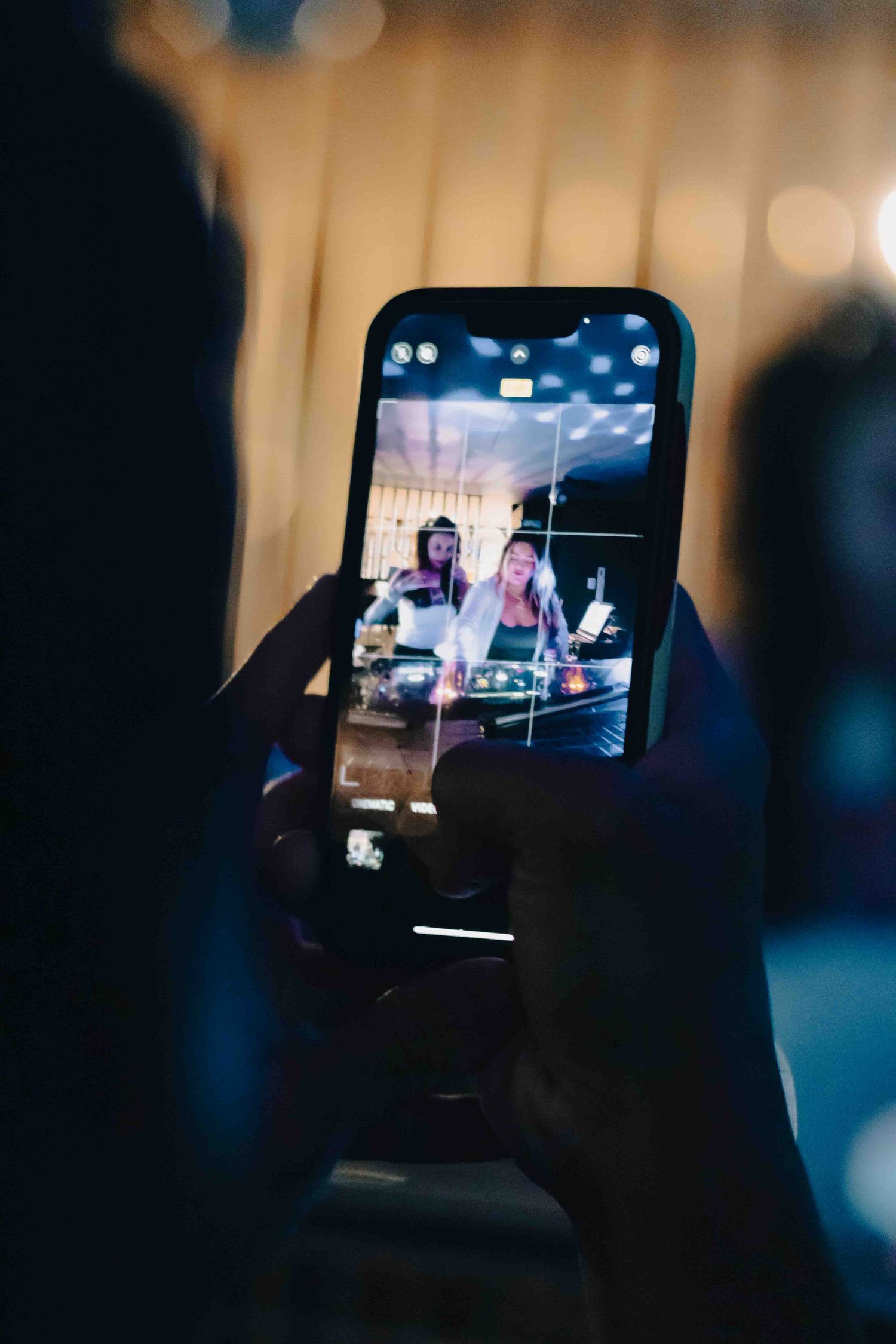 Mobile phones capturing video footage at a nighttime entertainment event.