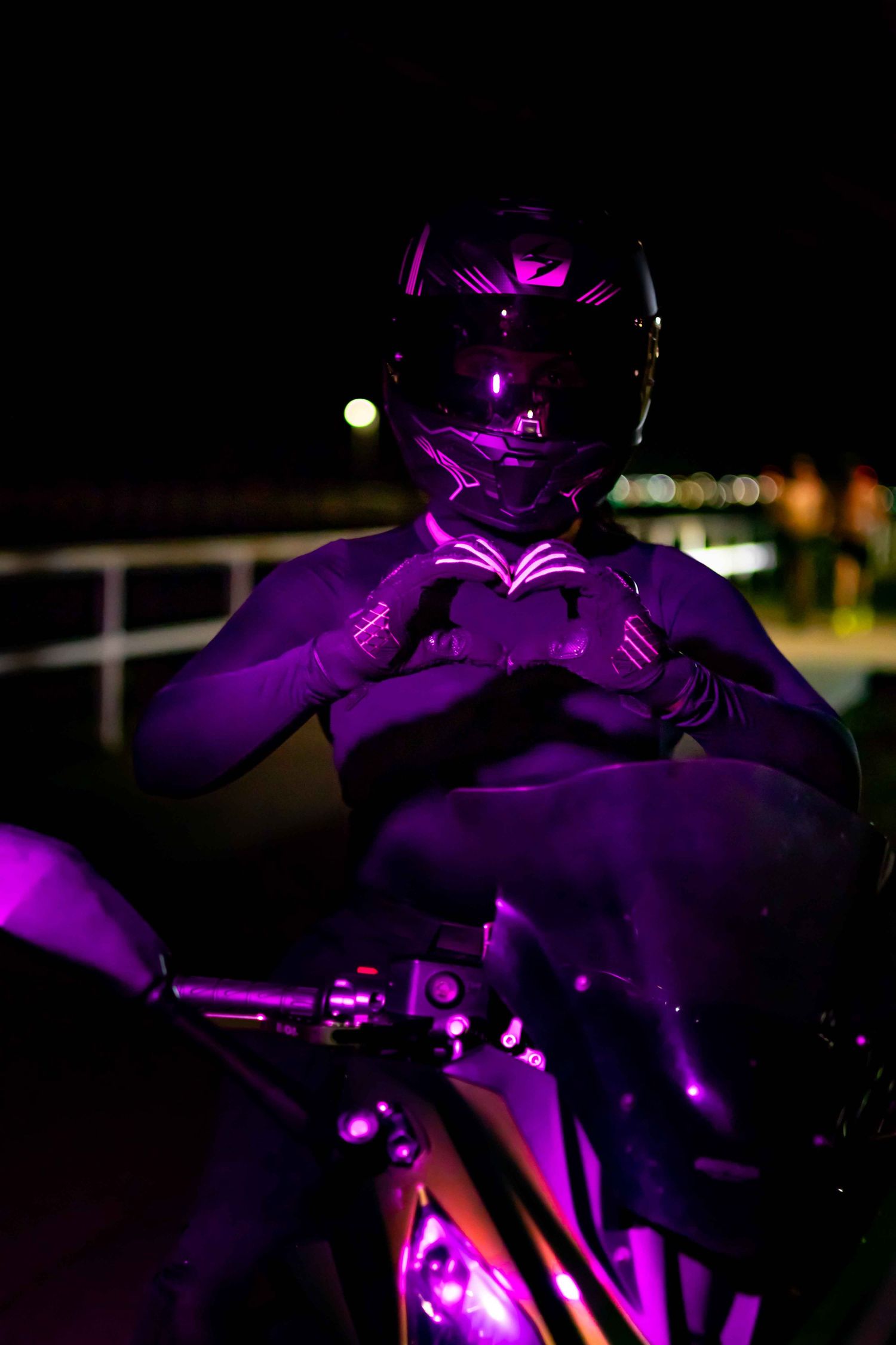 Motorcycle bathed in purple ambient lighting creating a dramatic nighttime scene.