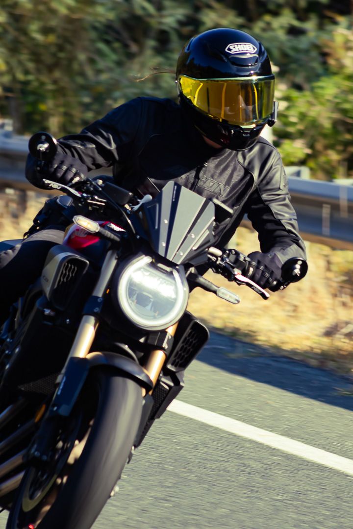 Sport motorcycle taking a tight corner on a mountain road with aggressive lean angle.