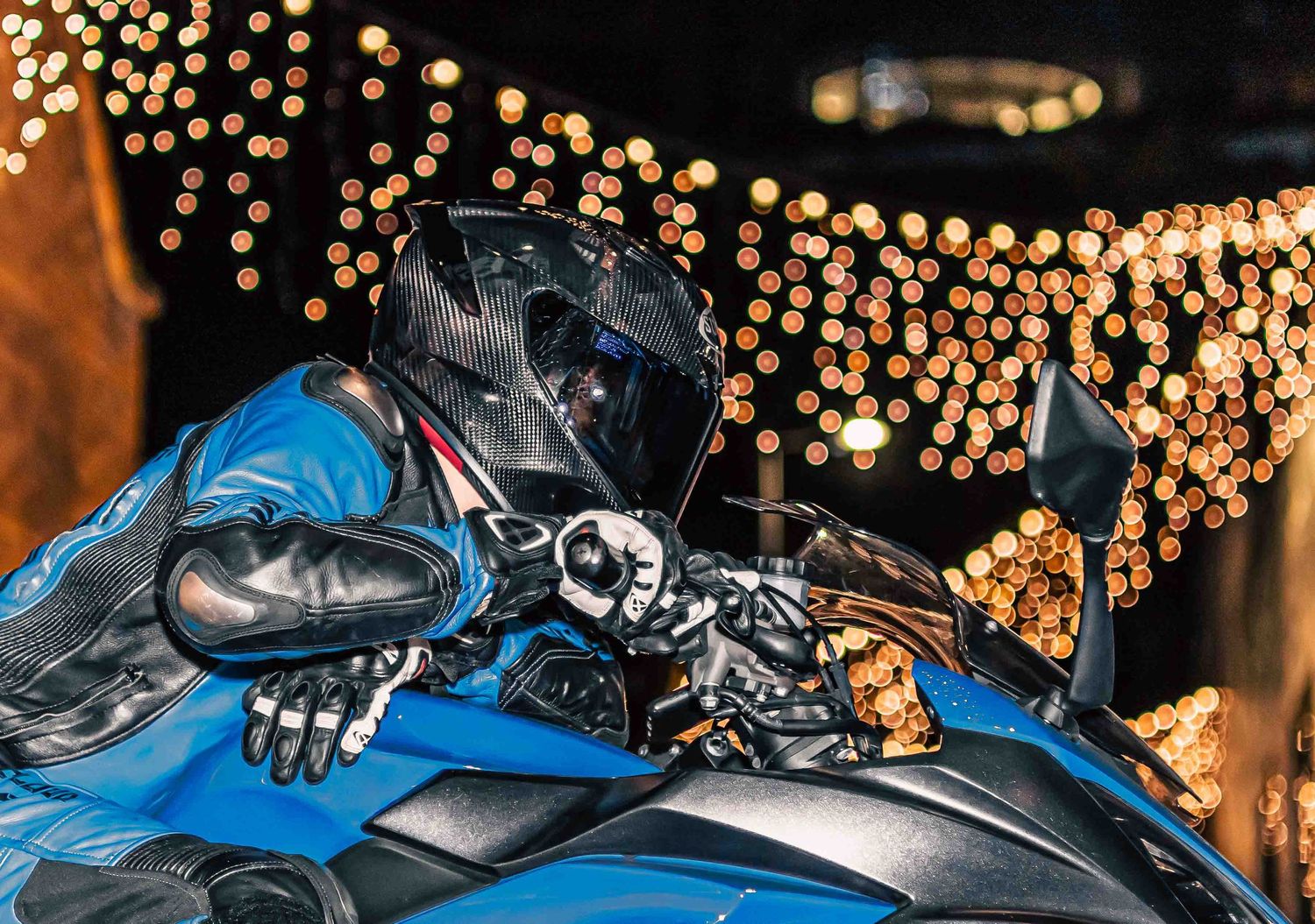 Motorcycle silhouette against bokeh lights creating a dramatic nighttime scene.