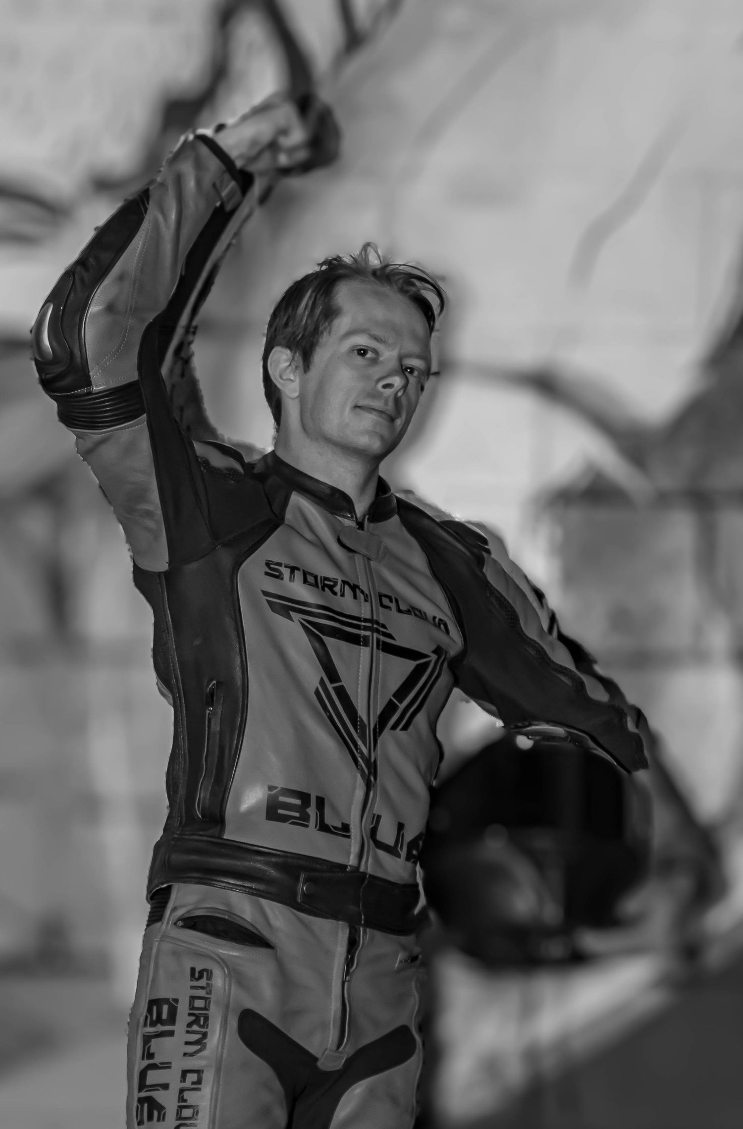 Motorcyclist in racing gear striking dynamic poses against light background.
