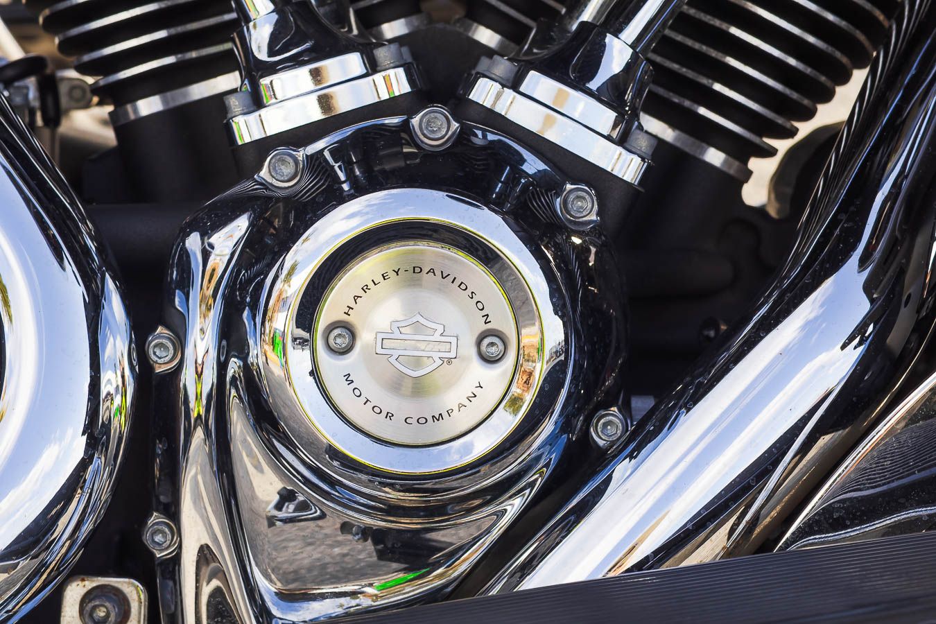 Close-up details of chrome motorcycle engine parts and mechanical components.
