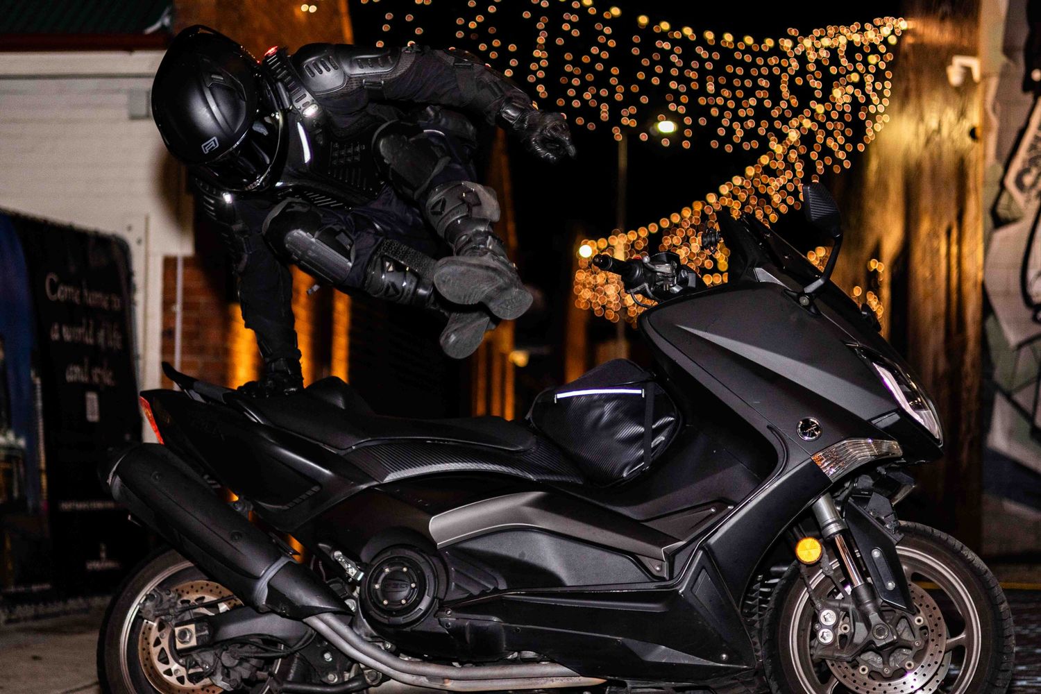 Motorcycle parked under warm string lights creating a cozy nighttime ambiance.