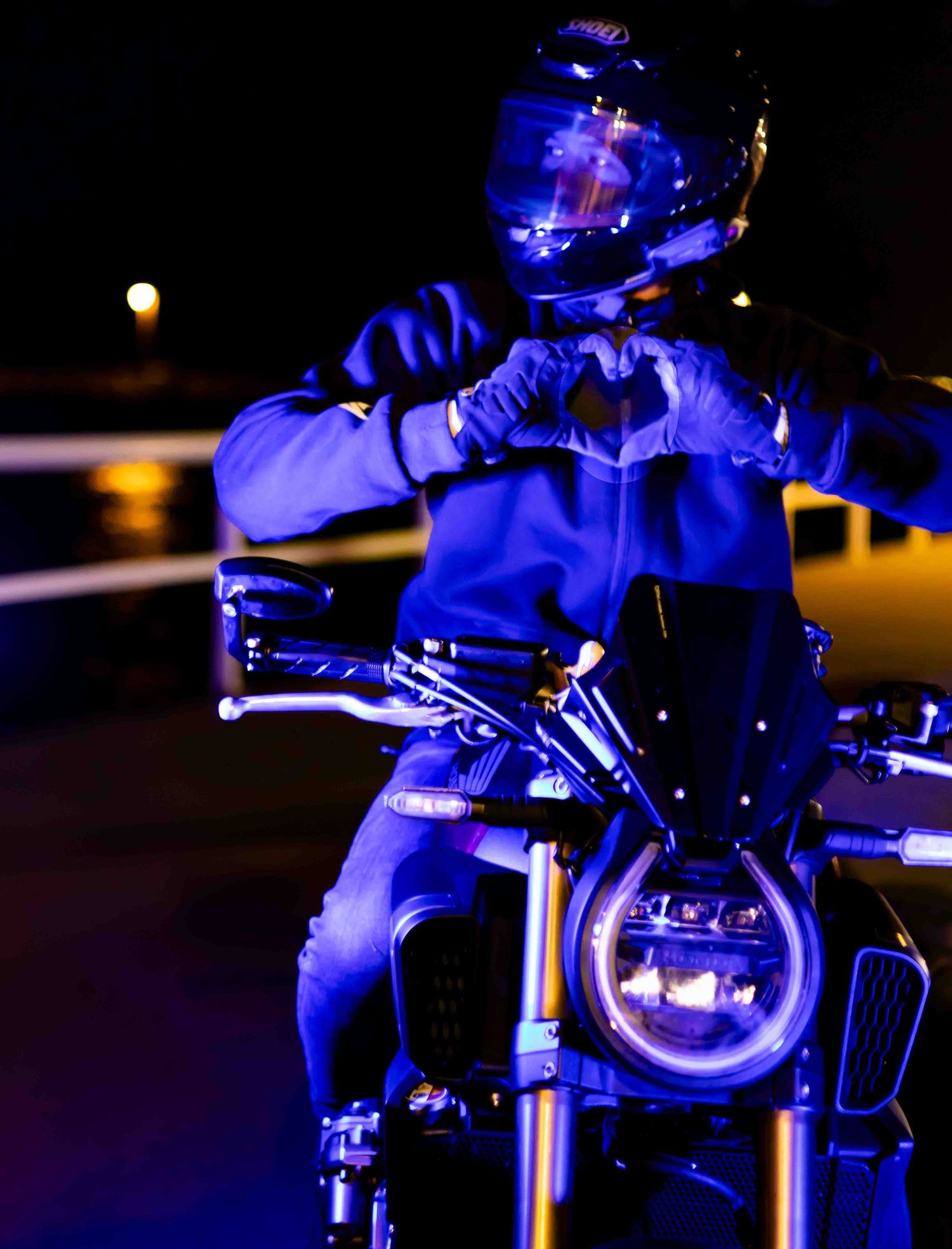 Sport motorcycle illuminated by blue lighting at night creating a moody atmosphere.