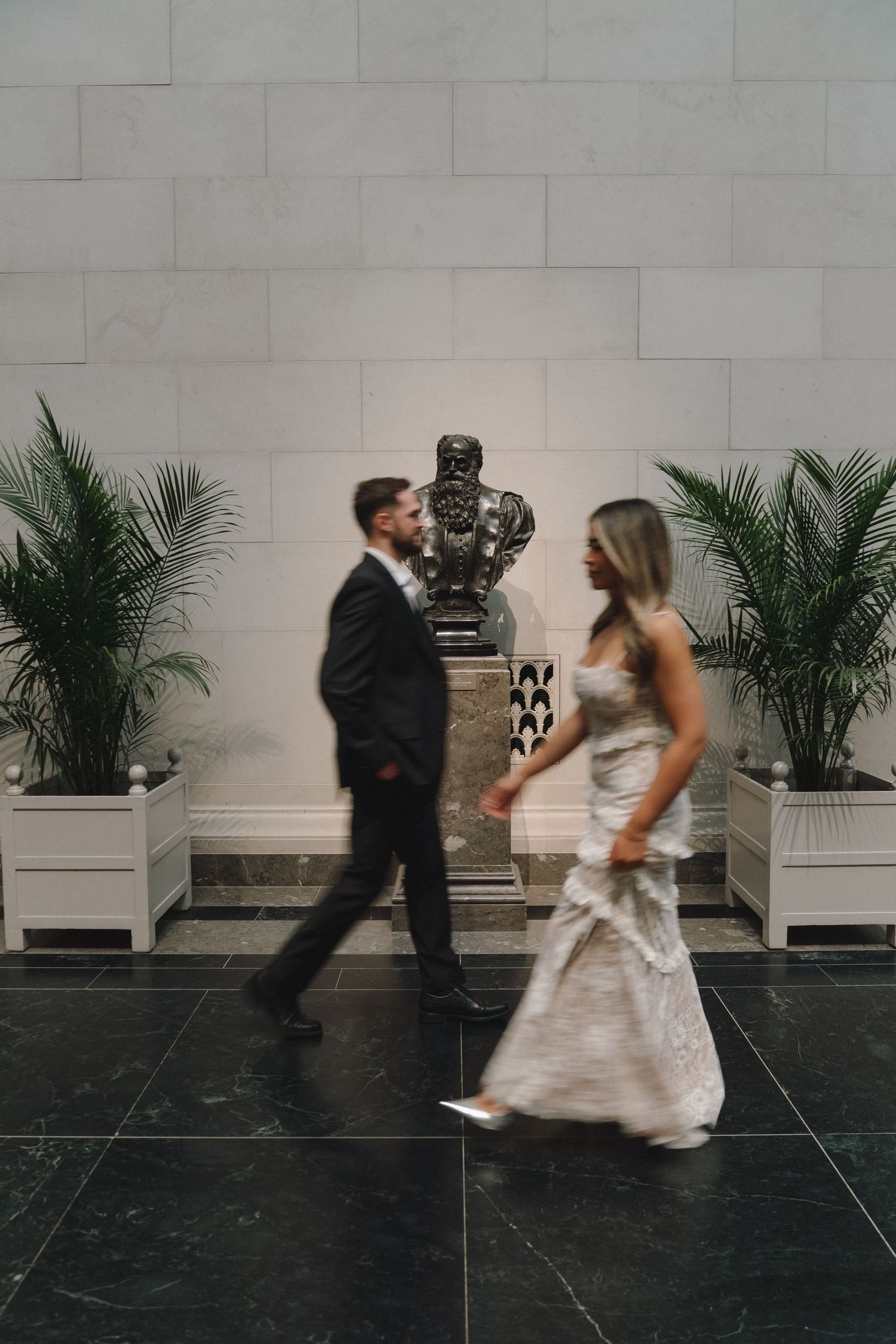 Intentionally blurred photo of a couple walking by a statue at the National Gallery of Art in Washington, D.C.