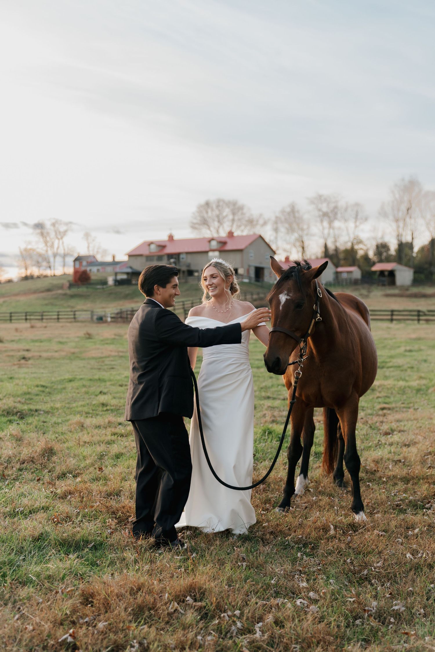 Couple petting a horse in their wedding attire at Riverside on the Potomac in Potomac, MD.