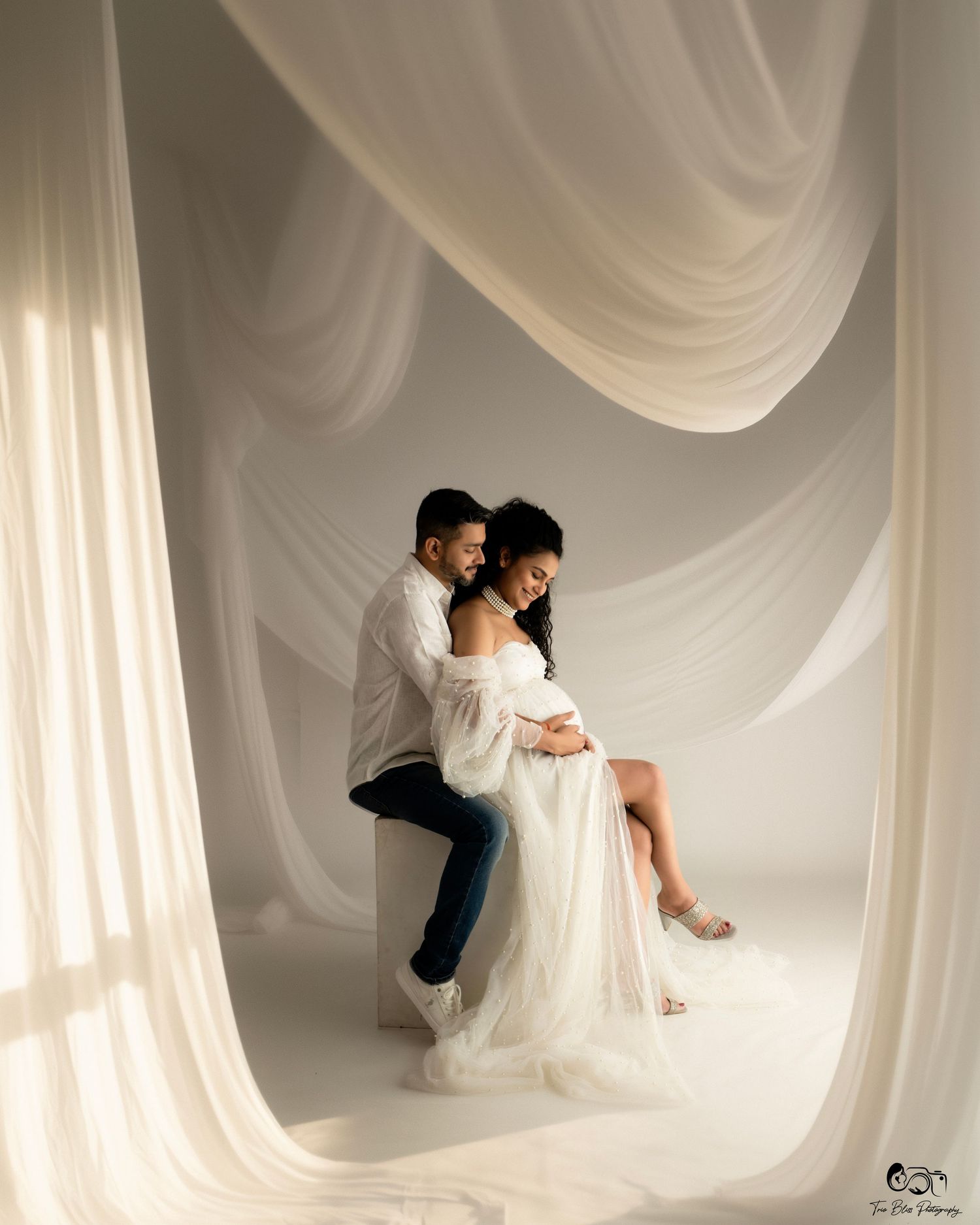 Black and white fine art photo series showing couple in romantic poses against flowing white fabric backdrop.