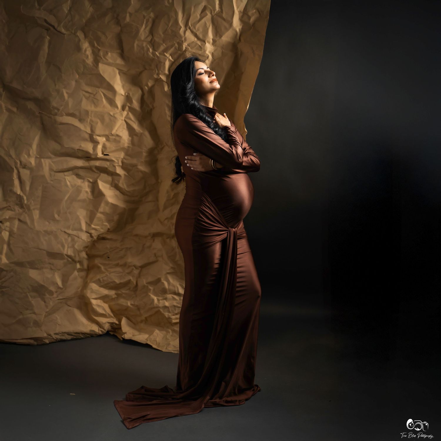 Atmospheric photo series showing a figure in dark brown fabric posing artistically against textured backdrop with shadow play.