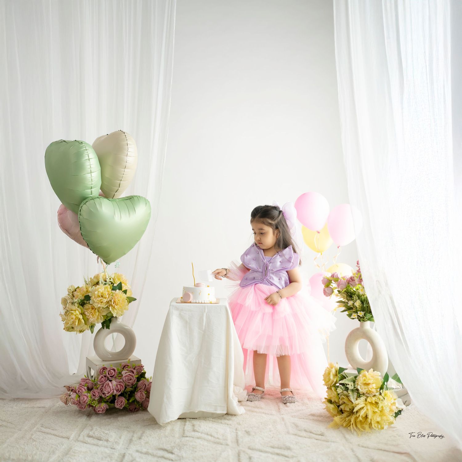 A series of whimsical photo scenes with heart balloons, pastel colors, and floral arrangements in a white studio setting.