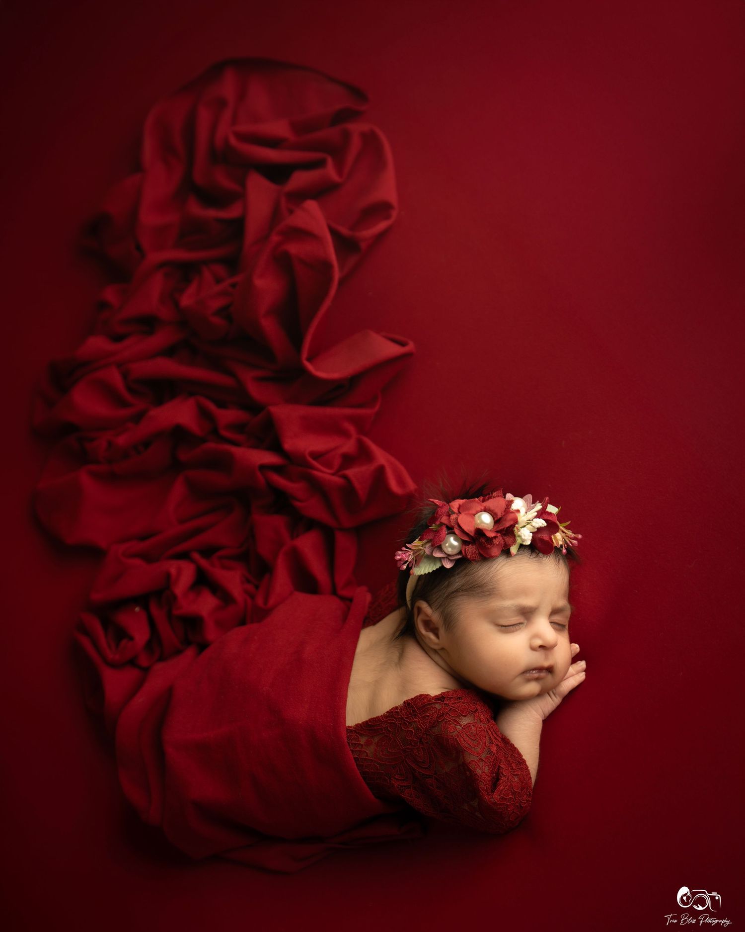 A textured red fabric backdrop creates a dramatic artistic setting.