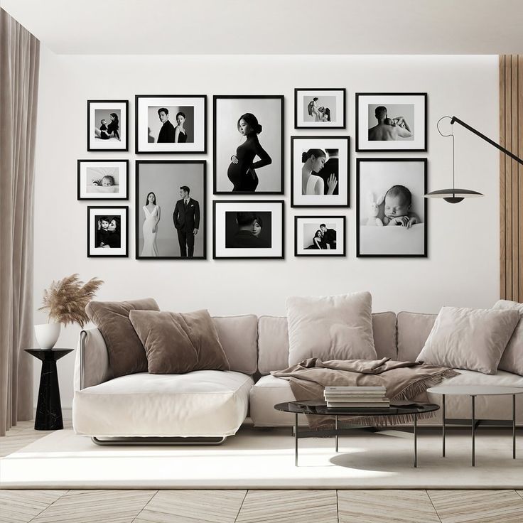 Black and white family photo gallery wall with framed portraits above a beige sofa in a modern living room.