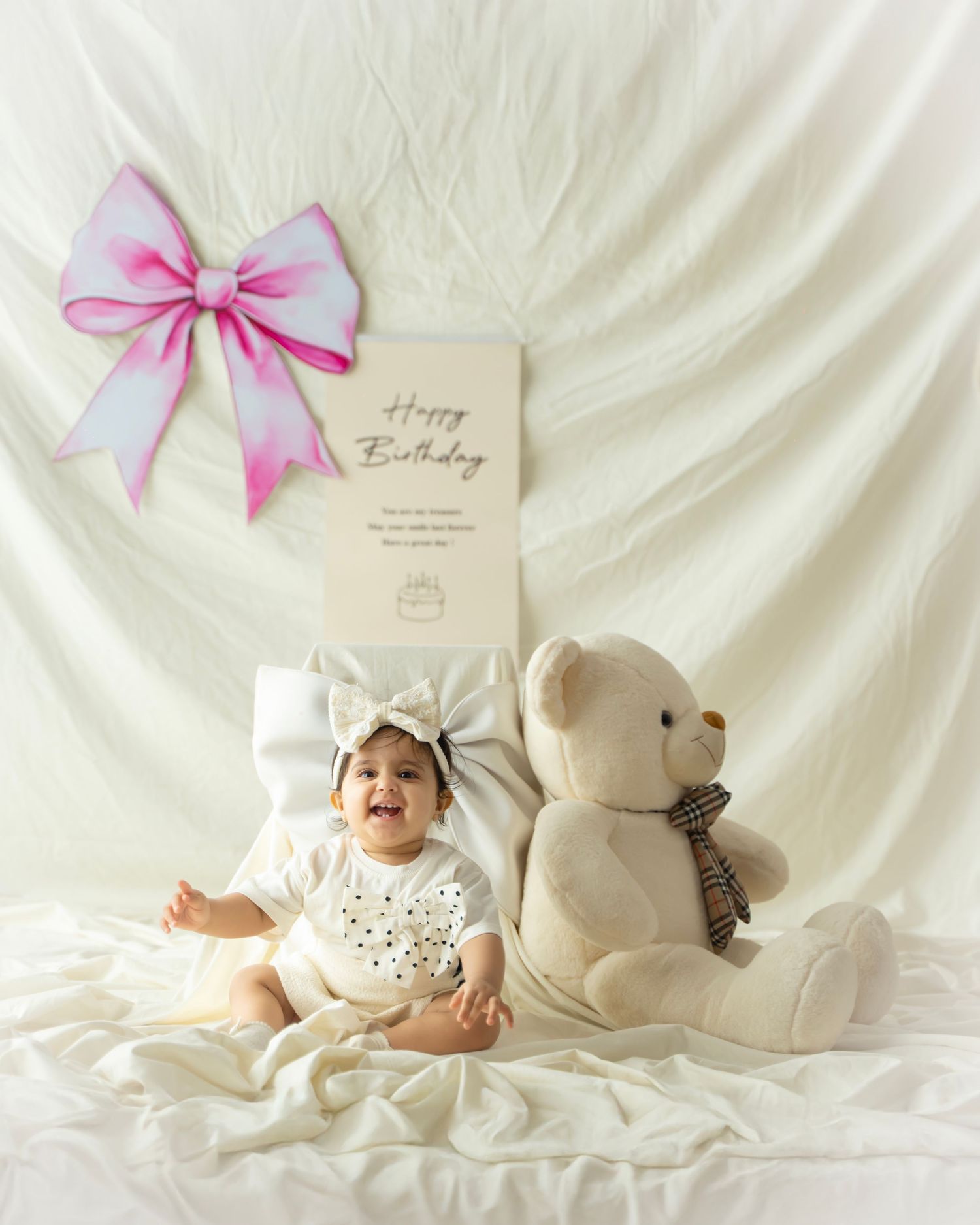 A series of soft white photos showing a teddy bear and baby with pink bow decorations against a light backdrop.