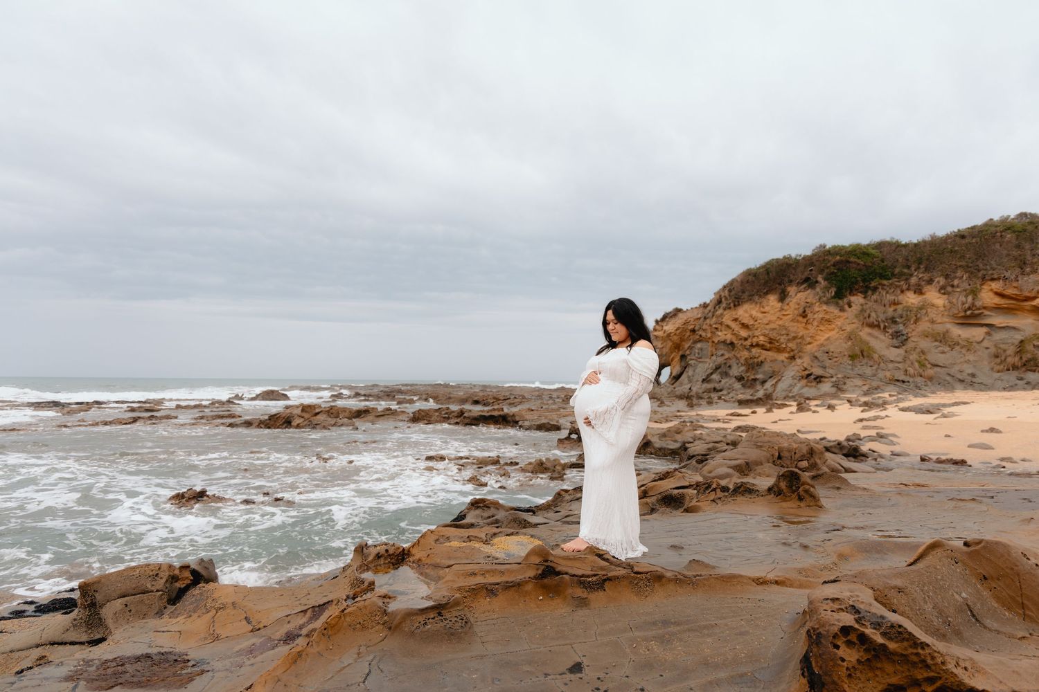 A coastal photoshoot series showing a figure in white dress walking along rocky cliffs by the ocean at sunset.