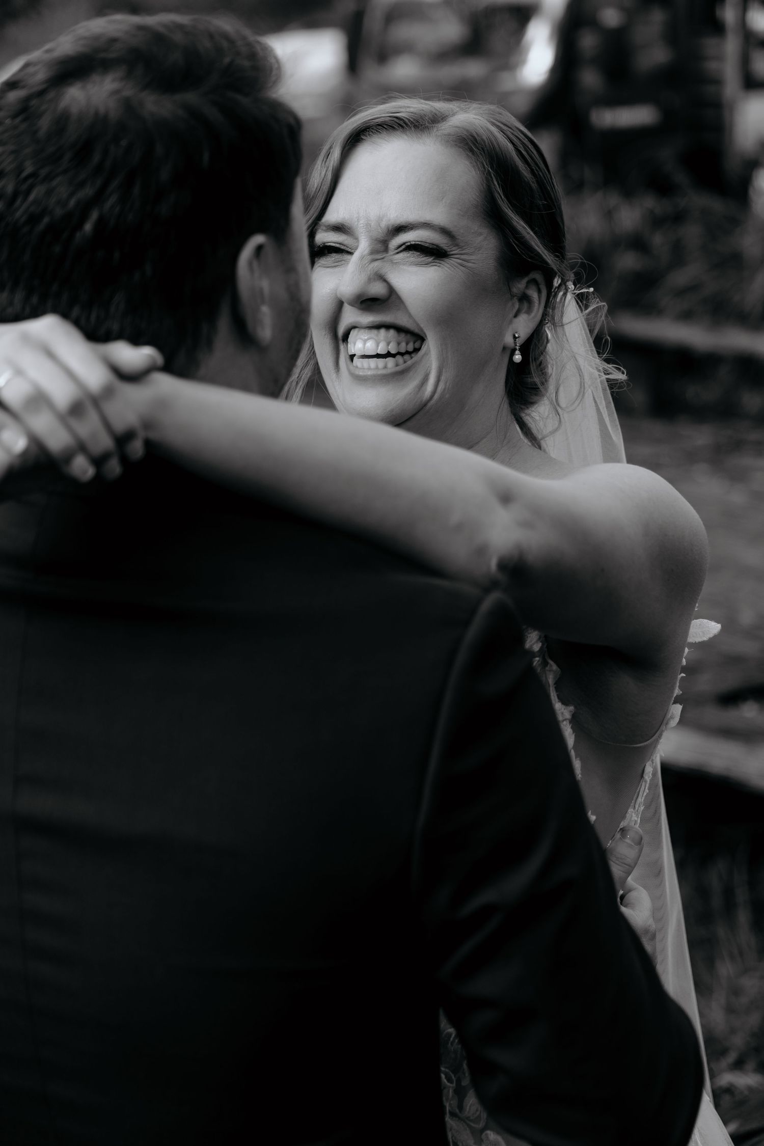 A black and white sequence of photos showing joyful candid reactions and laughter during a special moment.