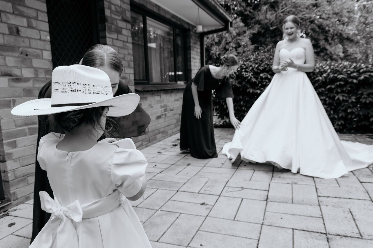 Black and white collage showing three outdoor wedding scenes with bridal attire and details on stone paving.