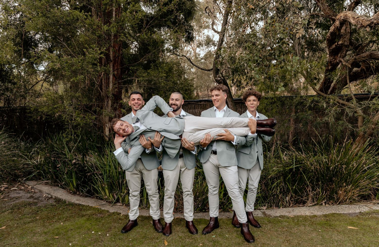 Wedding party members in light blue suits relax together on outdoor benches across multiple candid photos.