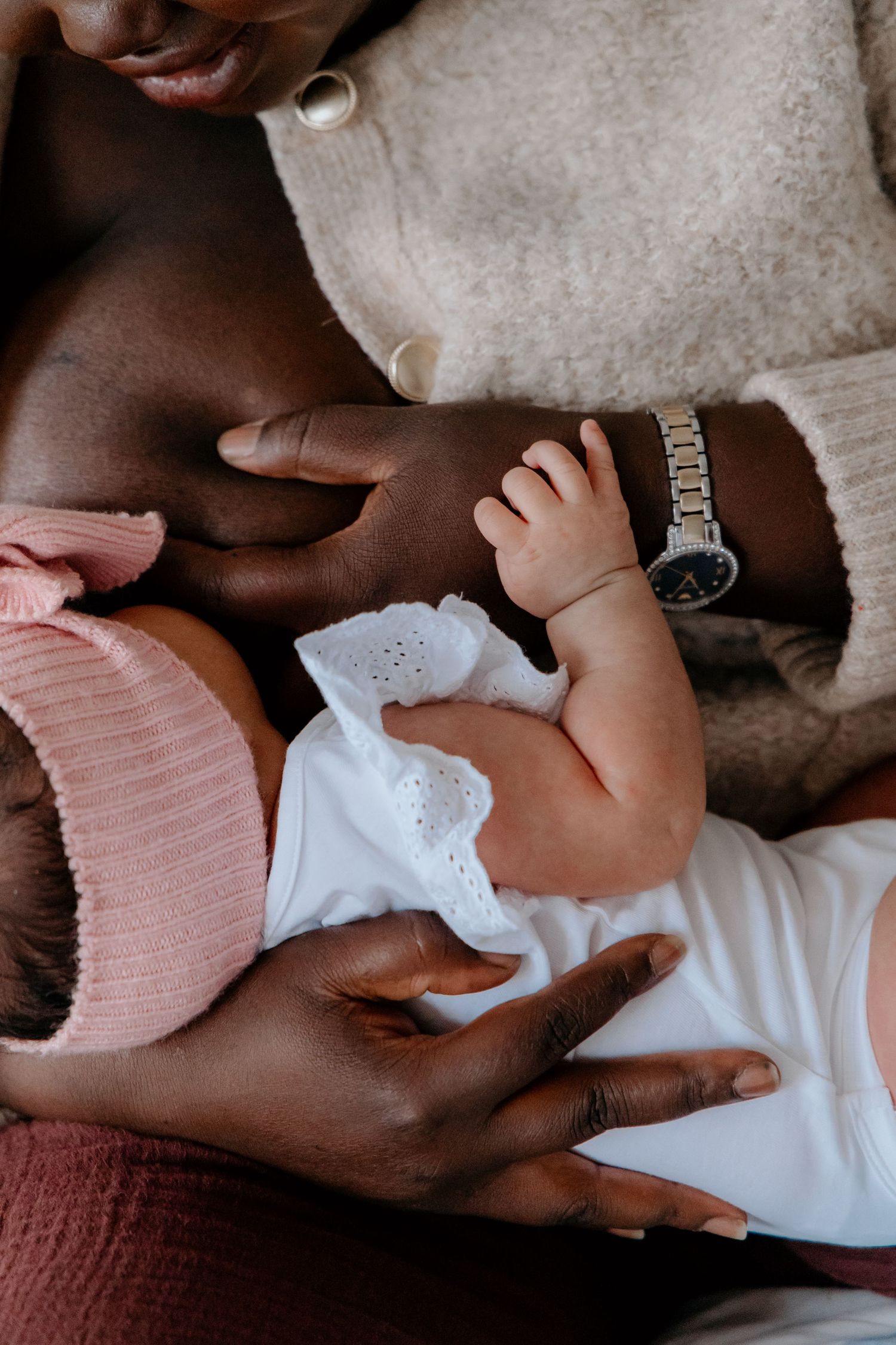 Close-up sequence showing gentle hands cradling and caressing in soft pink and white tones.