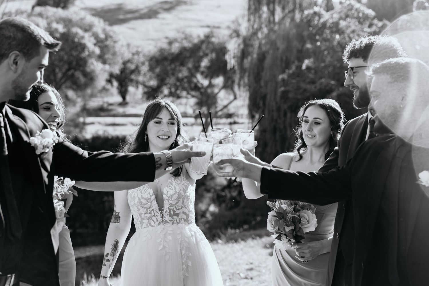 A series of black and white wedding photos showing romantic moments between a bride and groom in an outdoor setting.