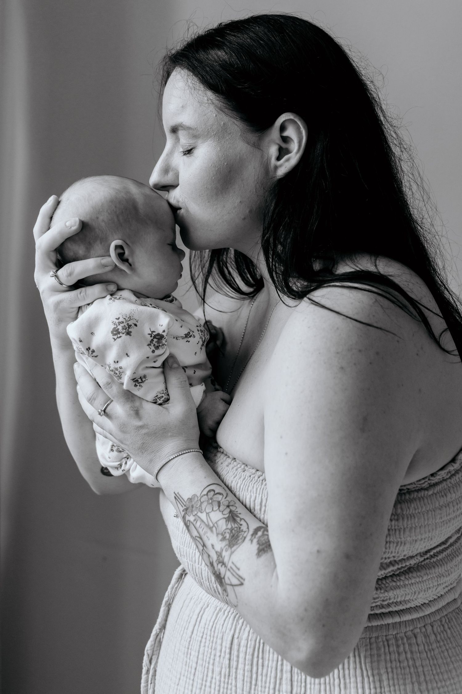 A tender black and white photo series showing intimate moments between parent and infant in soft natural light.