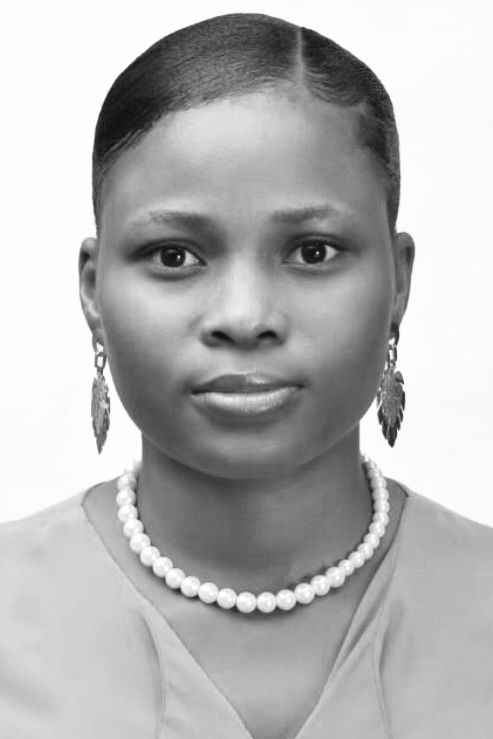 Black and white portrait of a woman wearing pearl necklace and leaf earrings, looking directly at camera.