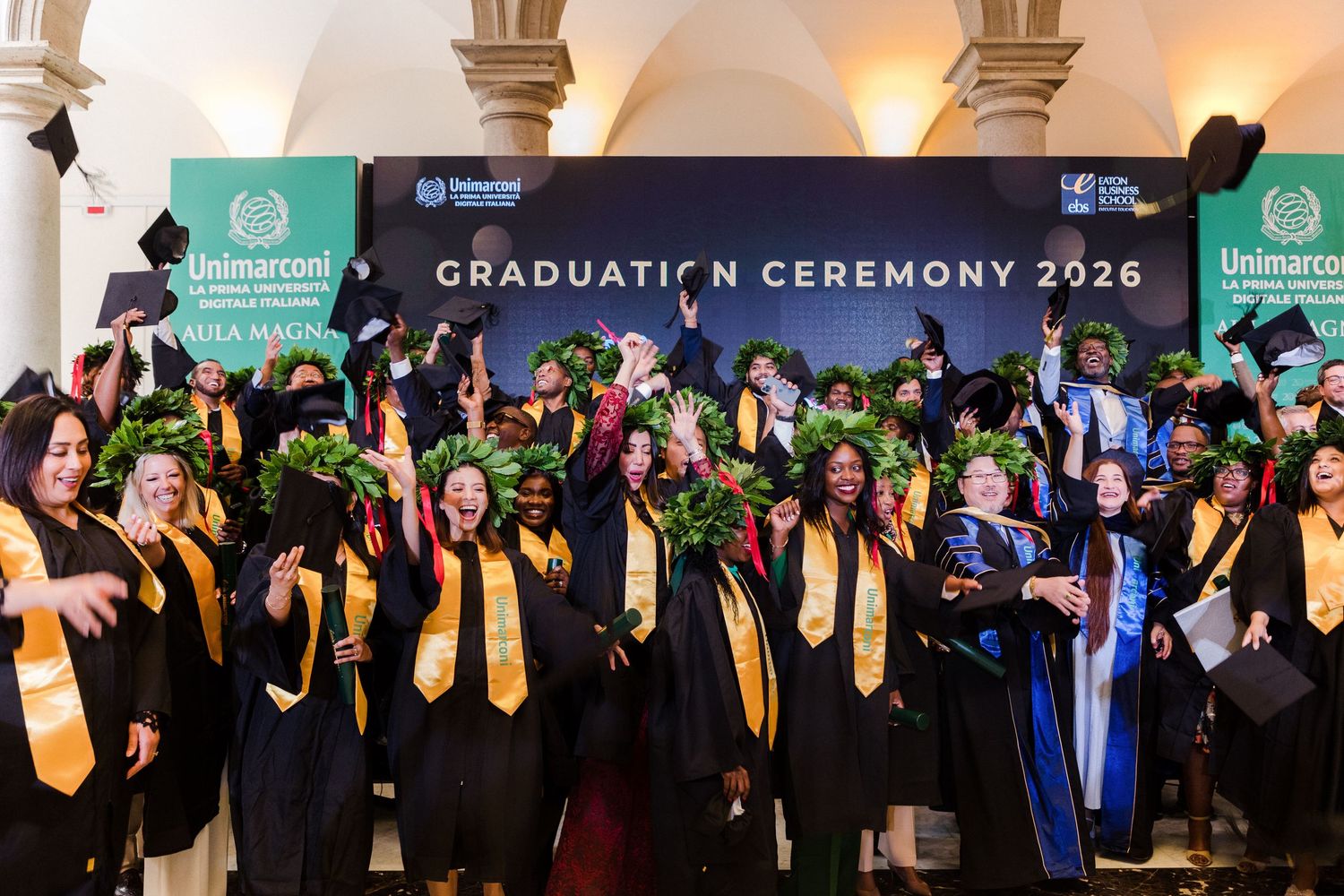 Graduates in caps and gowns celebrate at Unimarcon Graduation Ceremony 2026, cheering and tossing hats in joy.