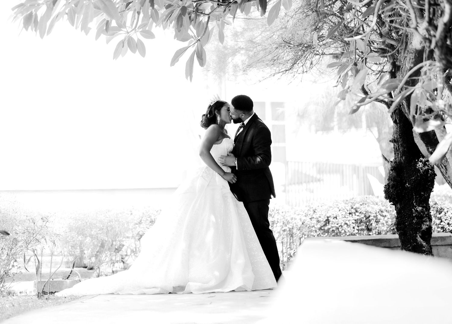 The bride and groom sharing a kiss outside the ceremony hall, with a scenic outdoor backdrop.