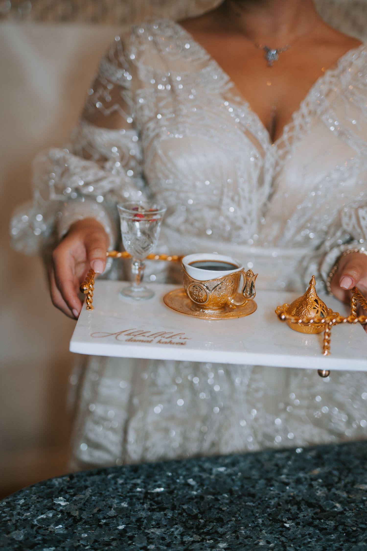 Elegant white beaded wedding dress detail with Turkish coffee served in ornate gold cups on marble tray.