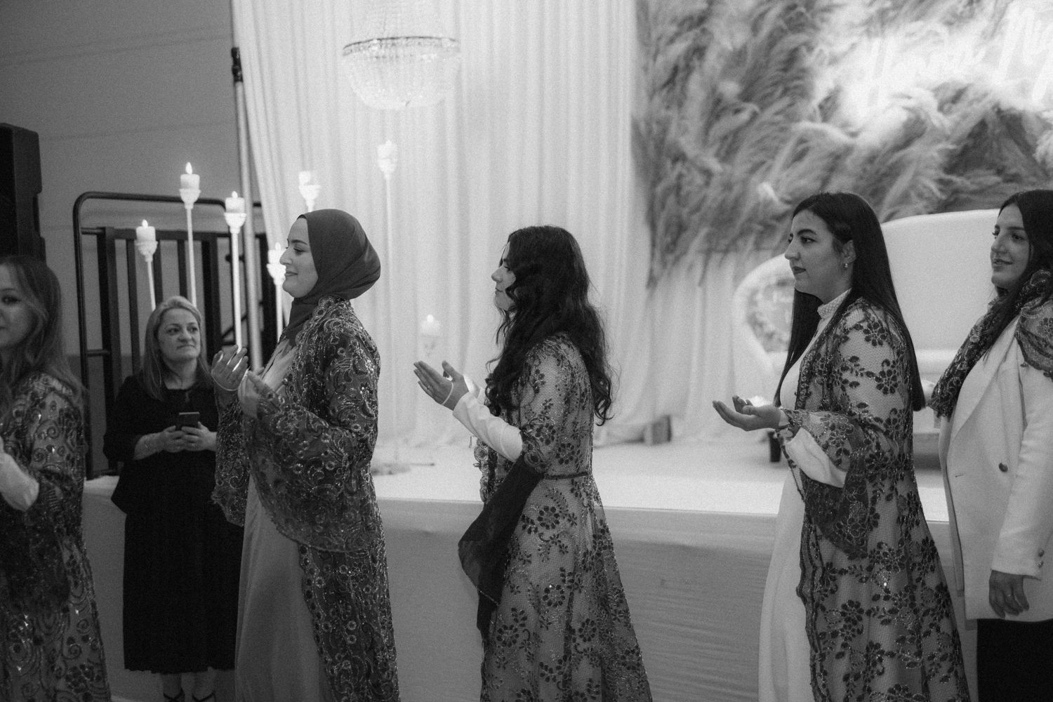 Wedding attendees in floral dresses standing in formation during celebration.