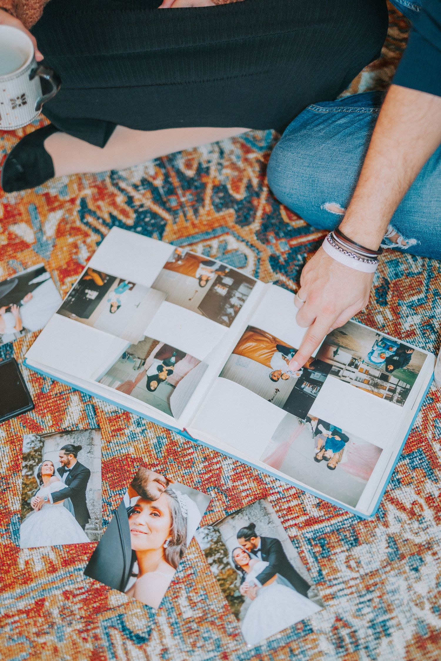 Photo album spread on ornate rug with scattered prints and memories.