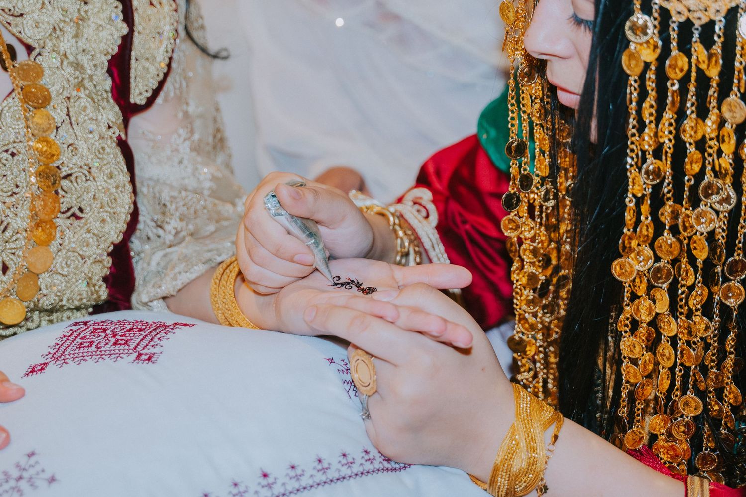 Hands wearing traditional jewelry during cultural ceremony.