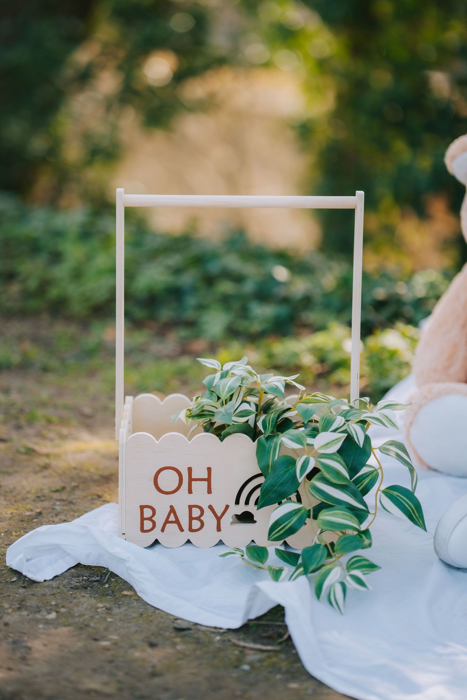 Decorative white frame with 'OH BABY' text and greenery for maternity photoshoot.