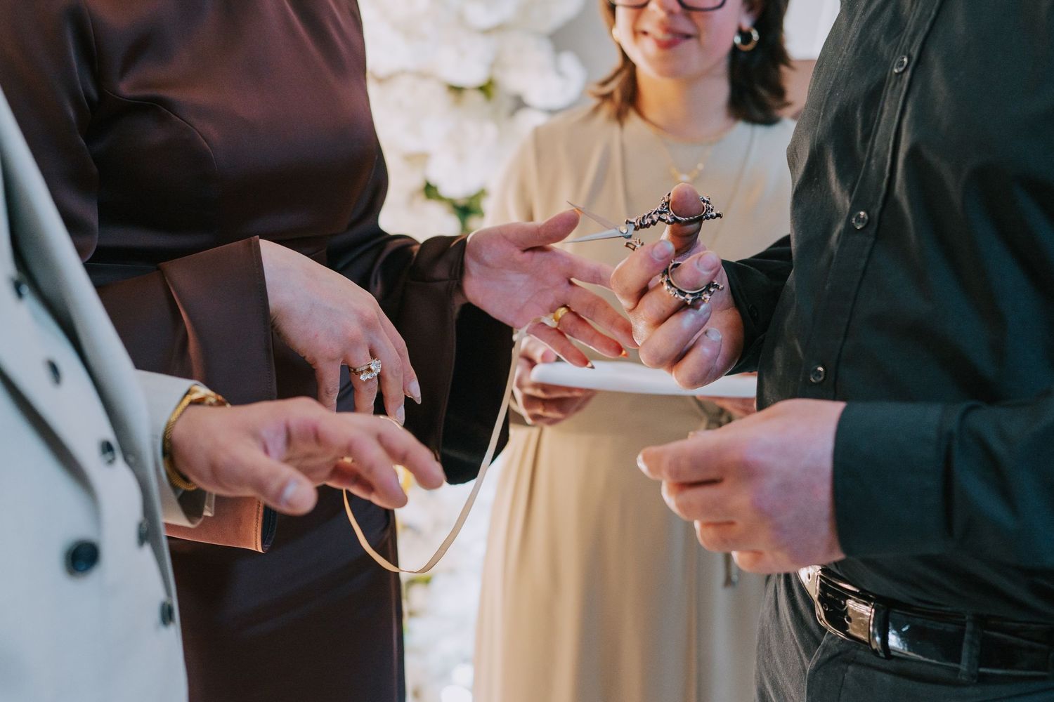Close-up of hands exchanging small items during what appears to be a ceremony.