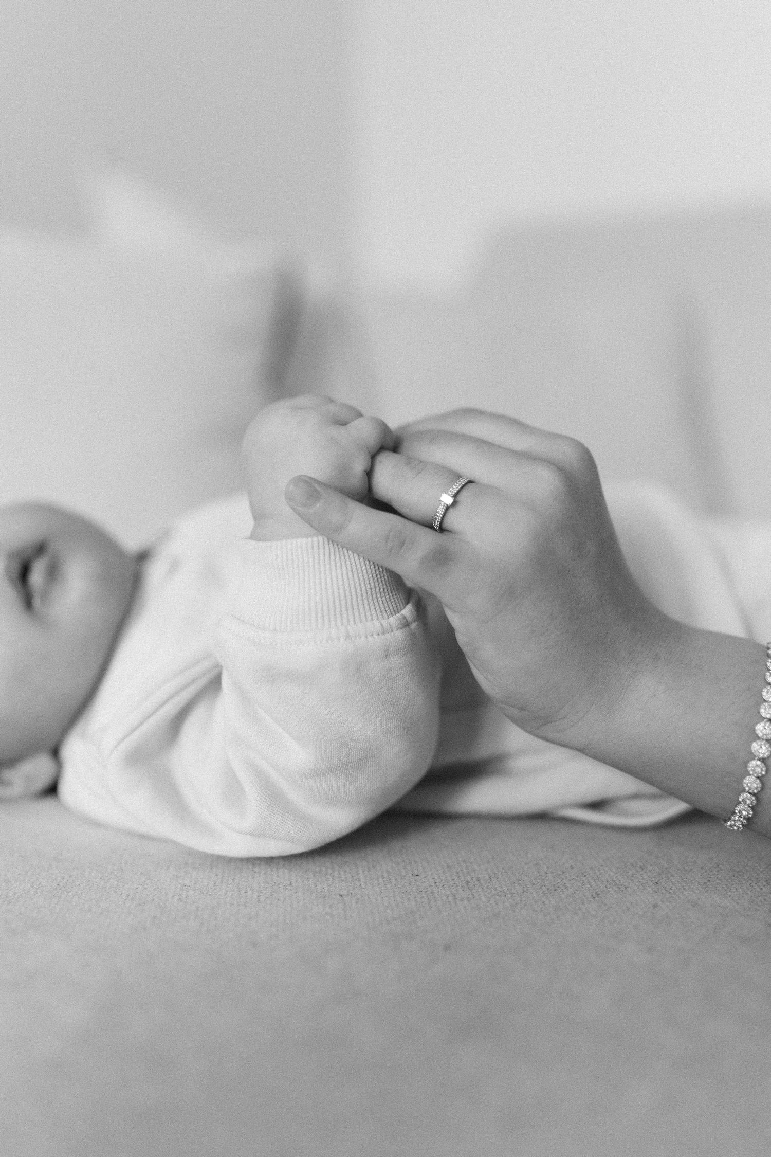 A series of black and white photos showing baby feet in white socks lying on a soft surface.