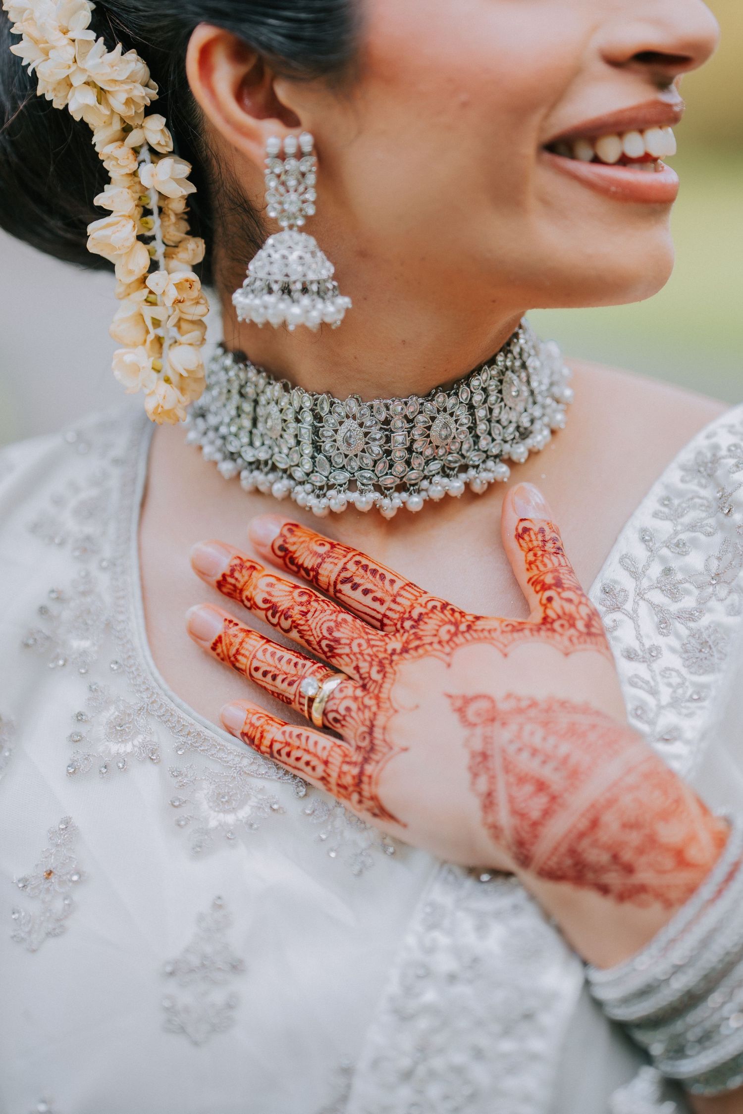 Intricate bridal jewelry with mehndi hands and crystal choker necklace.