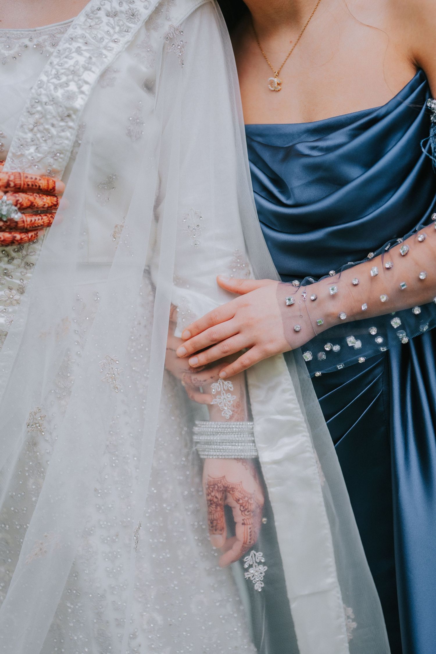 Detail of wedding dress and bridesmaid's blue dress with pearl embellishments.