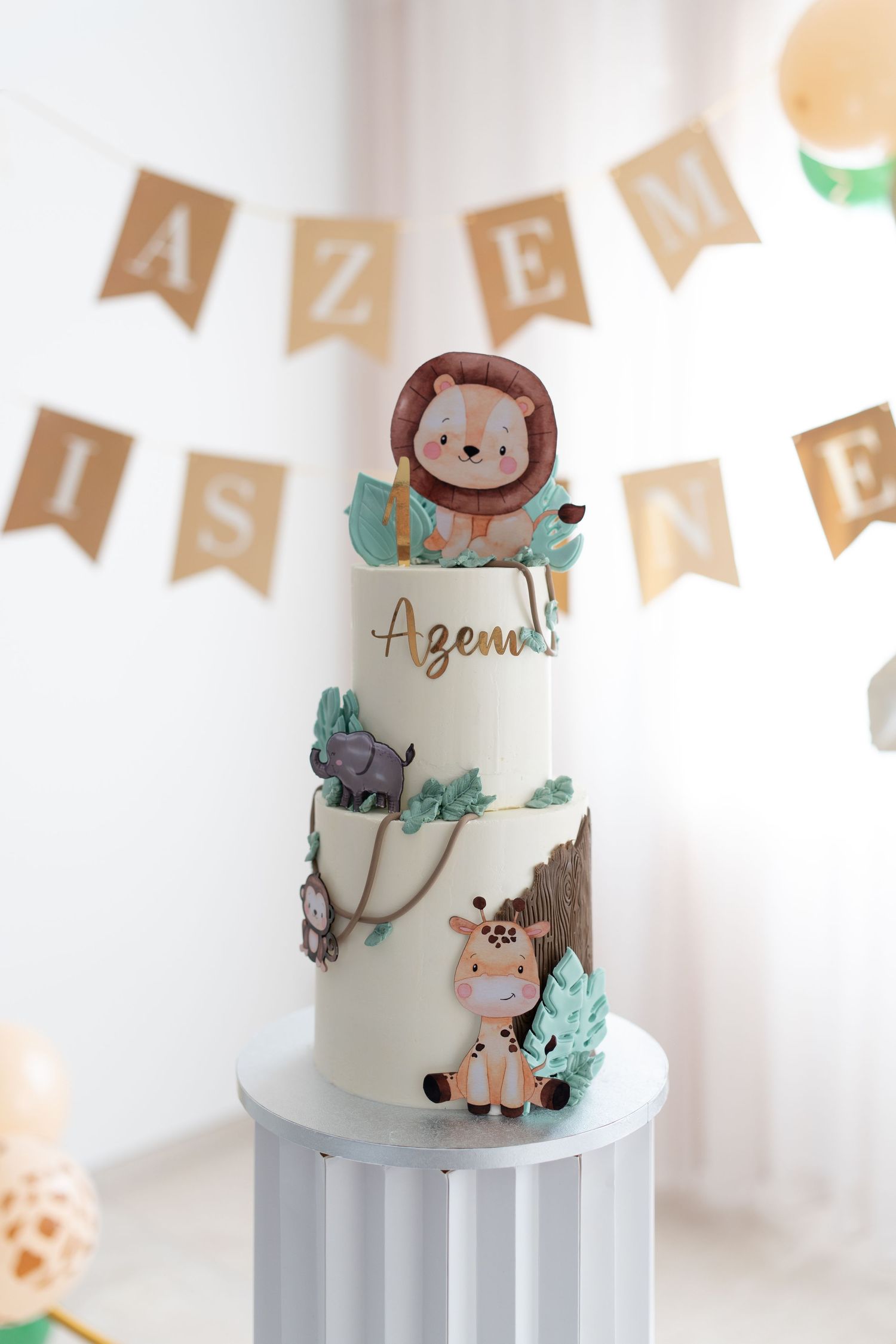 White wedding cake decorated with adorable woodland animal figures and mint green accents on a modern pedestal stand.