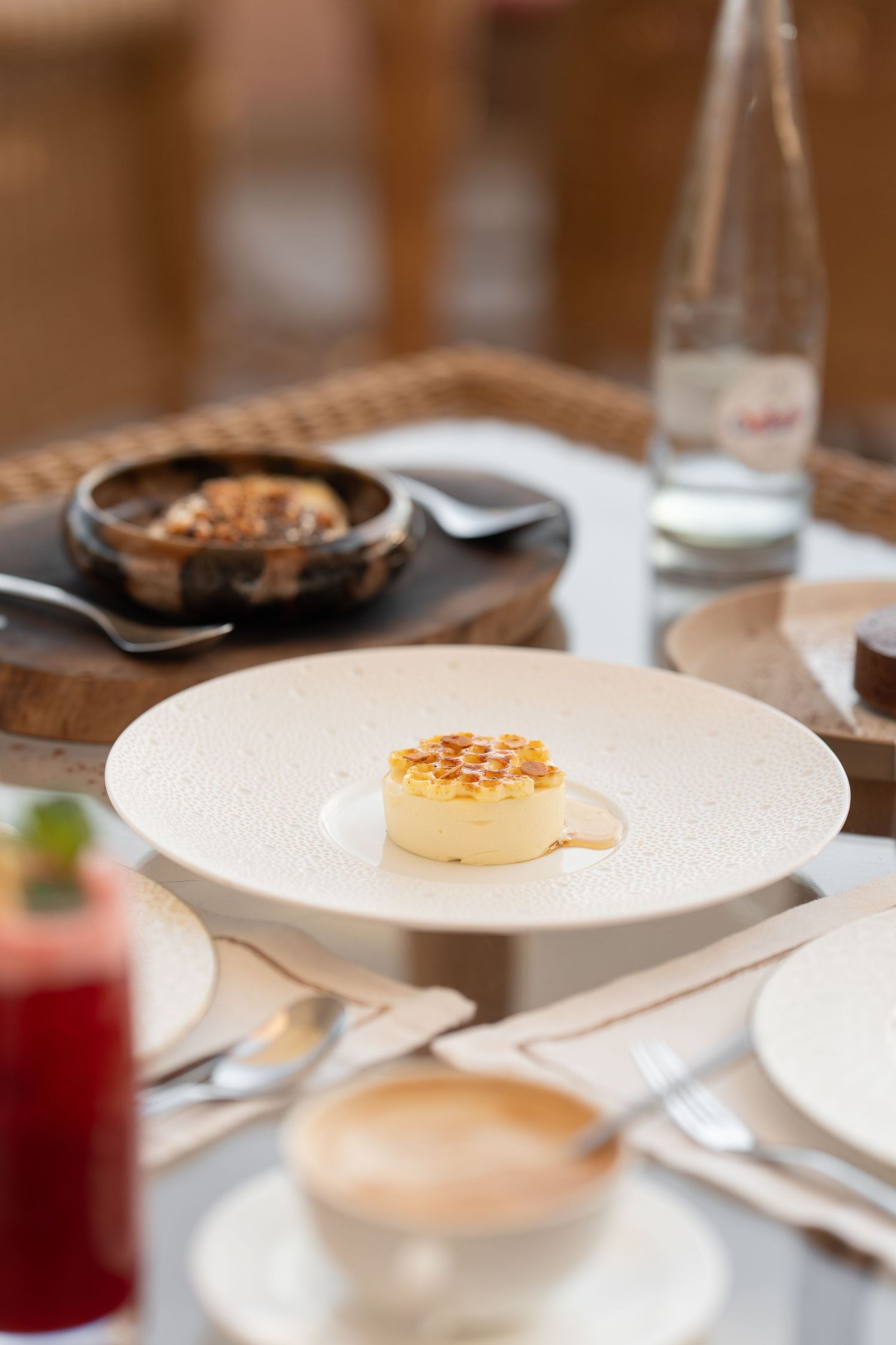 Elegant plated dessert with caramel sauce served on white dish in fine dining setting.
