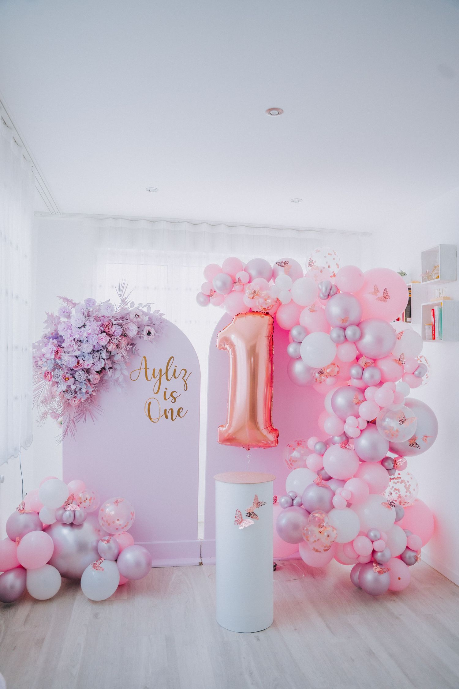 Pink and purple balloon arch with number one decoration for first birthday party.