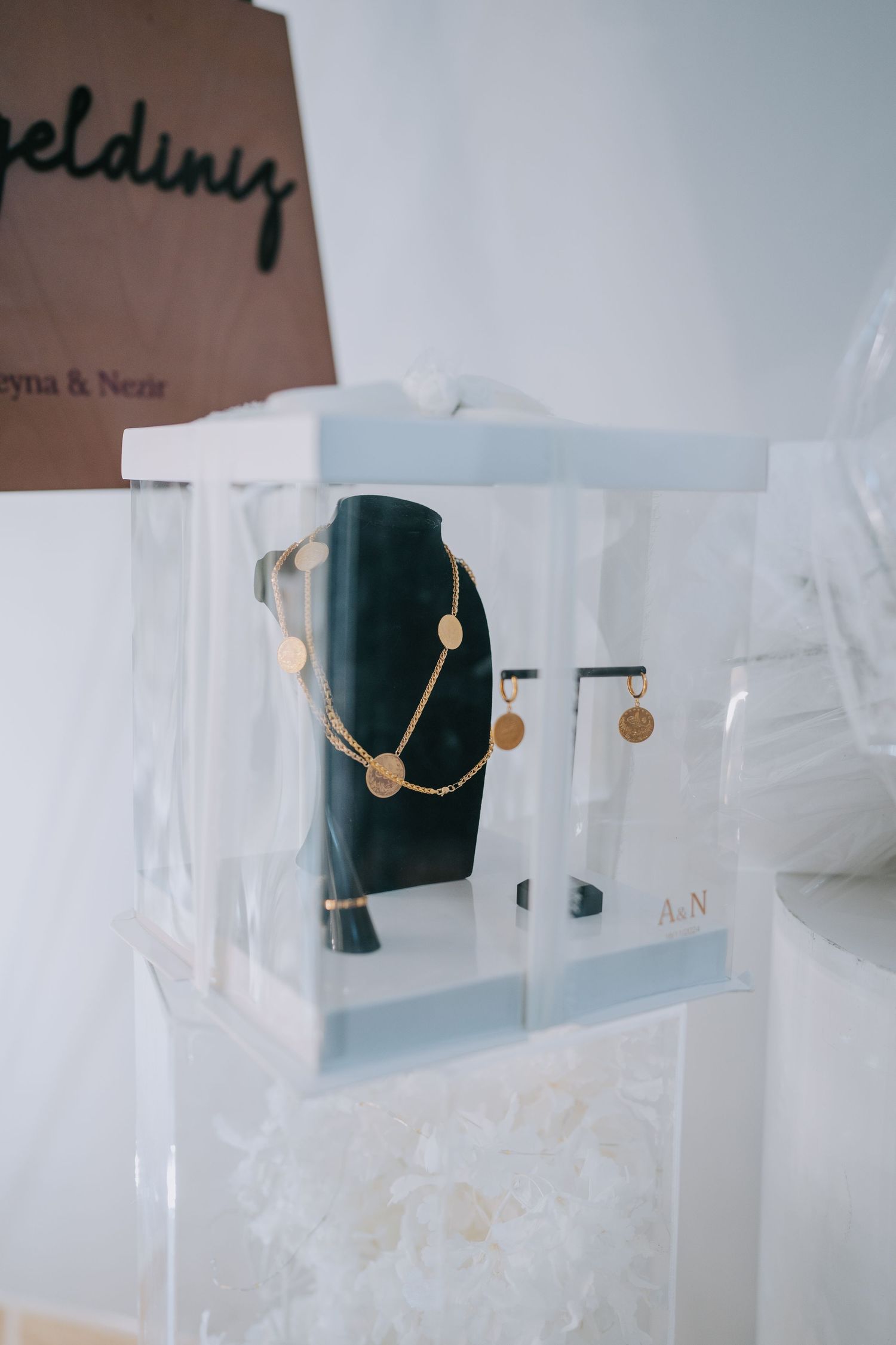 Display case showing jewelry pieces including a necklace on a black stand.