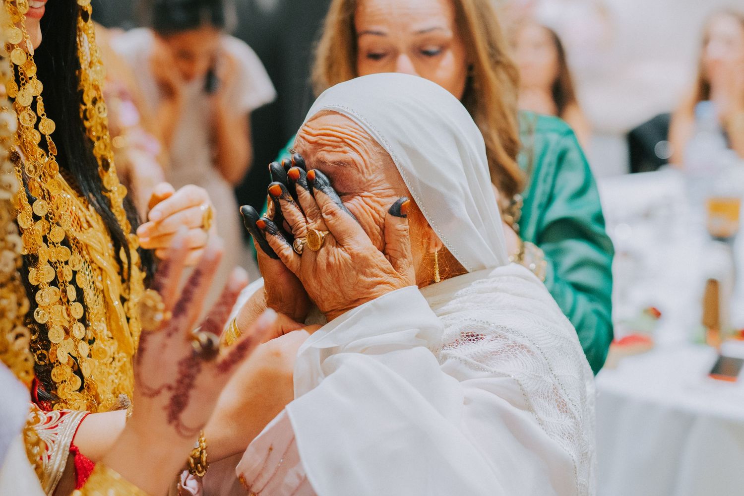 Emotional moment during traditional celebration wearing white headscarf.