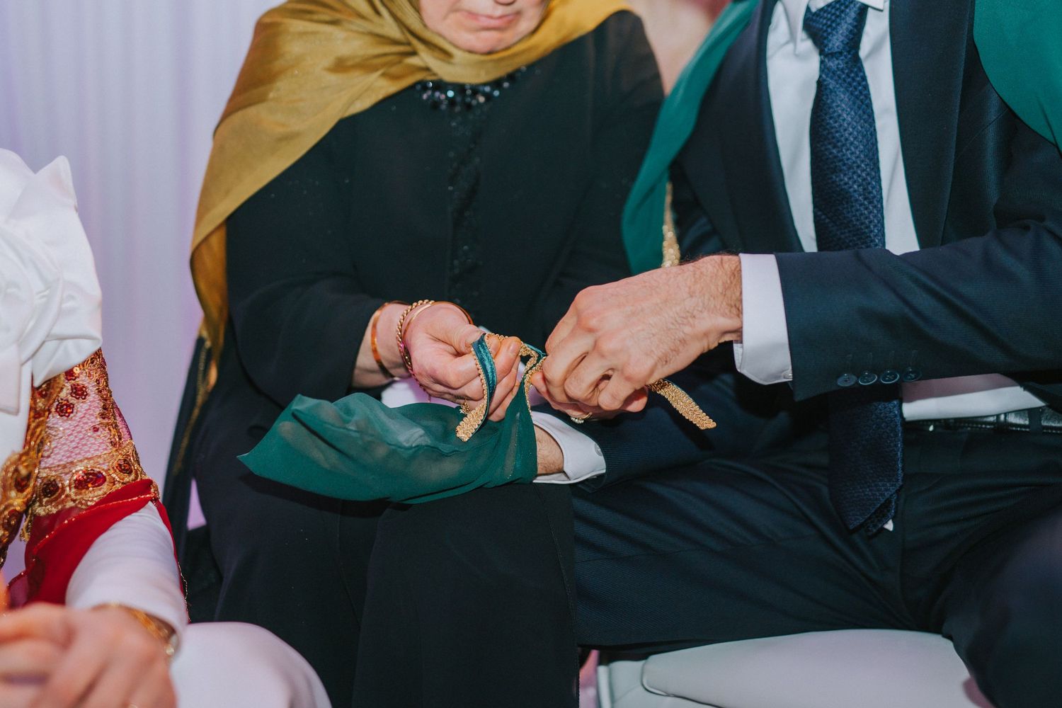 Close-up of hands exchanging rings during traditional wedding ceremony.