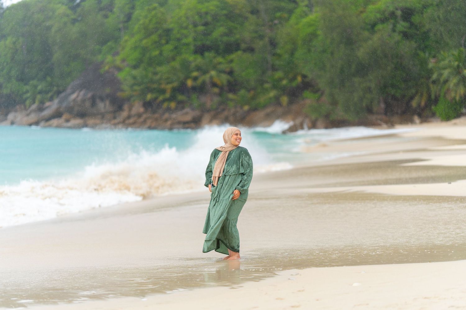 Figure walking along a pristine tropical beach with turquoise waters.