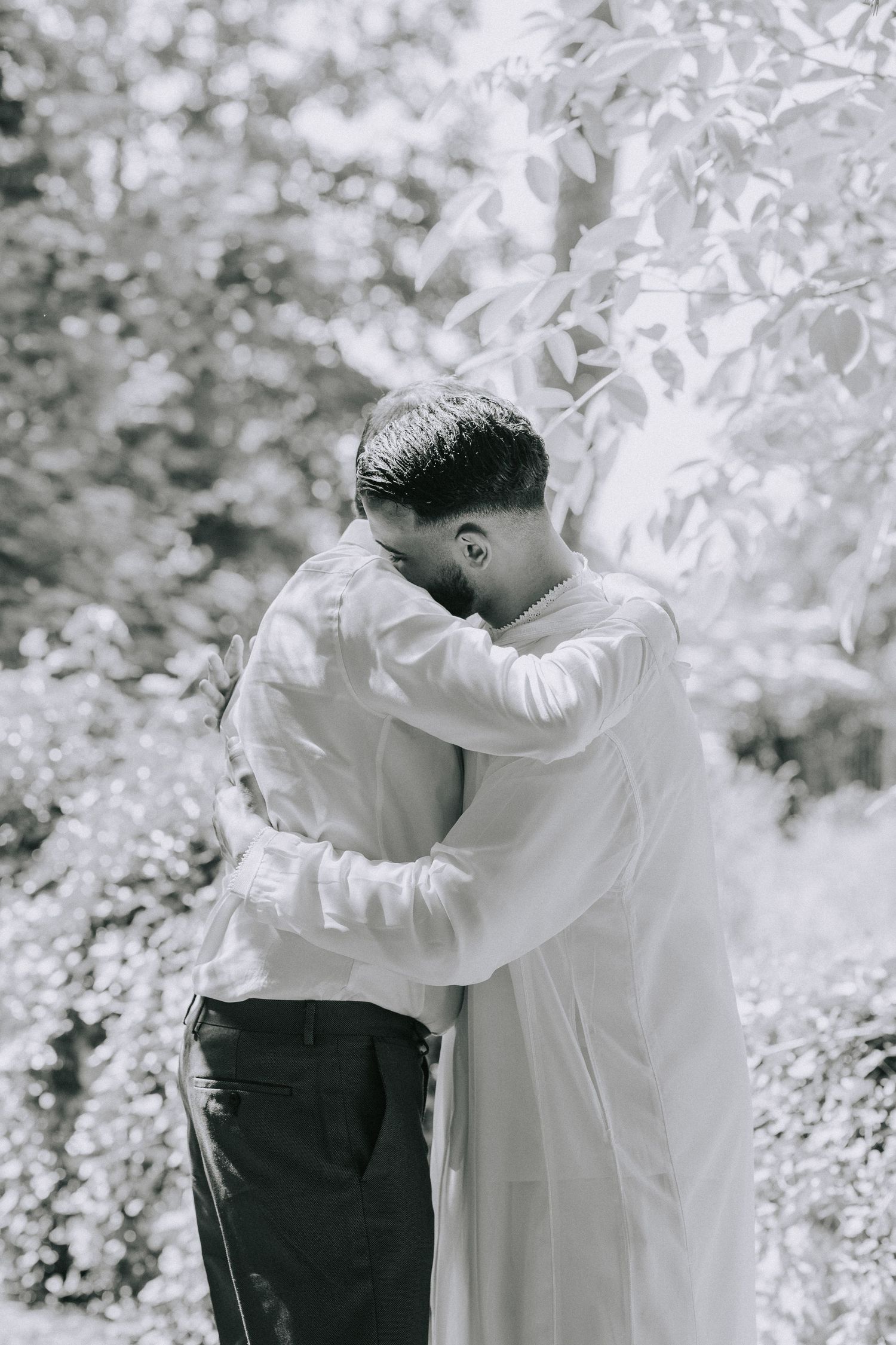 Intimate black and white portrait of a couple embracing outdoors.