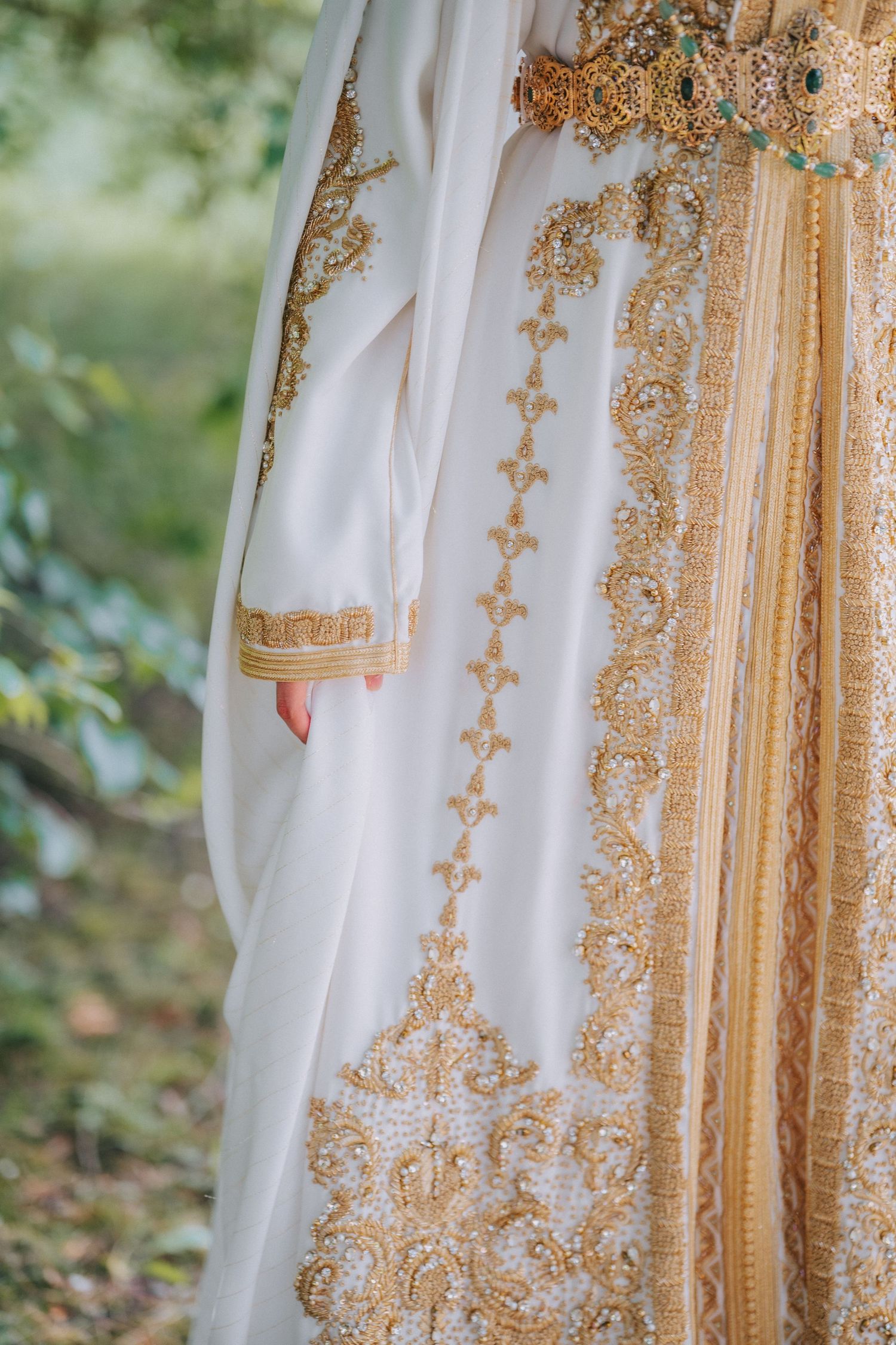 Detailed shot of ornate gold embroidery on white traditional South Asian wedding attire.