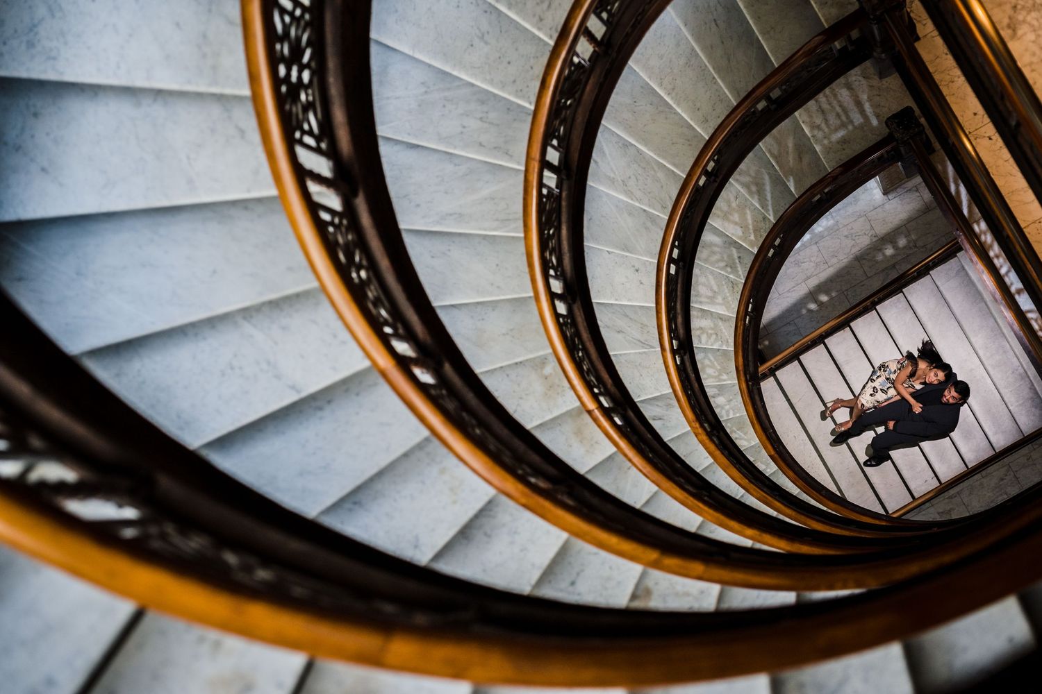 A spiral staircase with golden railings creates a mesmerizing geometric pattern.